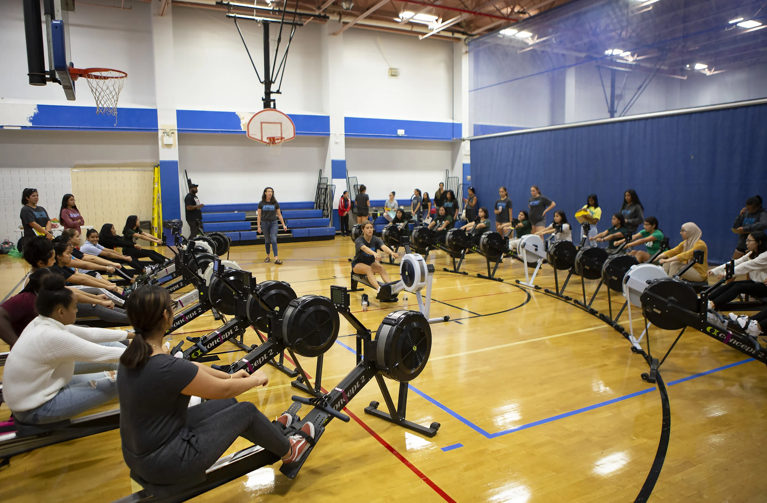  Bre Fitzsimmons, the Queens varsity coach, leads a number of recruits through instructions on how to begin rowing on an erg. Tryouts for RowNY were held at the Long Island City YMCA on Wednesday, Sept. 25, 2019.  