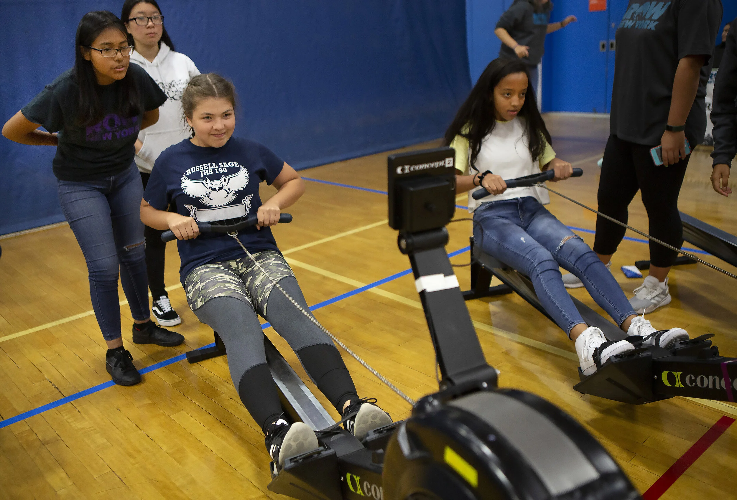  Sebastiana Lopez, left, tells recruit Mariya Sergeeva, an 8th grader at Russell Sage Junior High School, to try and row harder to hit a certain number on the erg, with fellow recruit Ariana Reyes, right, also rowing alongside her. Tryouts for RowNY 