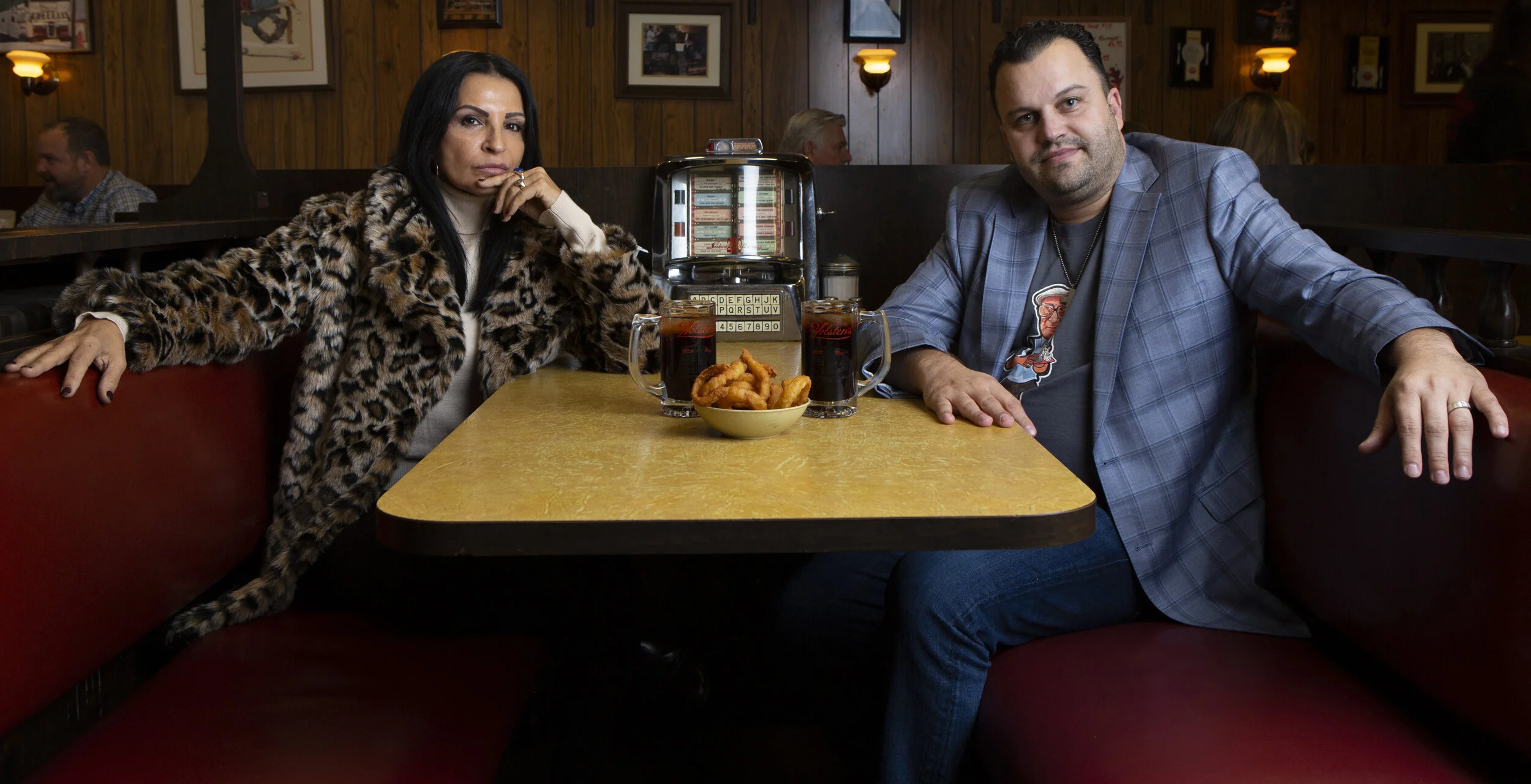  Kathrine Narducci, who plays Charmaine Bucco in The Sopranos, sits with SopranosCon organizer Michael Mota in the infamous booth where the final episode of the show was filmed at Holsten’s in Bloomfield, New Jersey, on Wednesday, Nov 20, 2019. Cast 