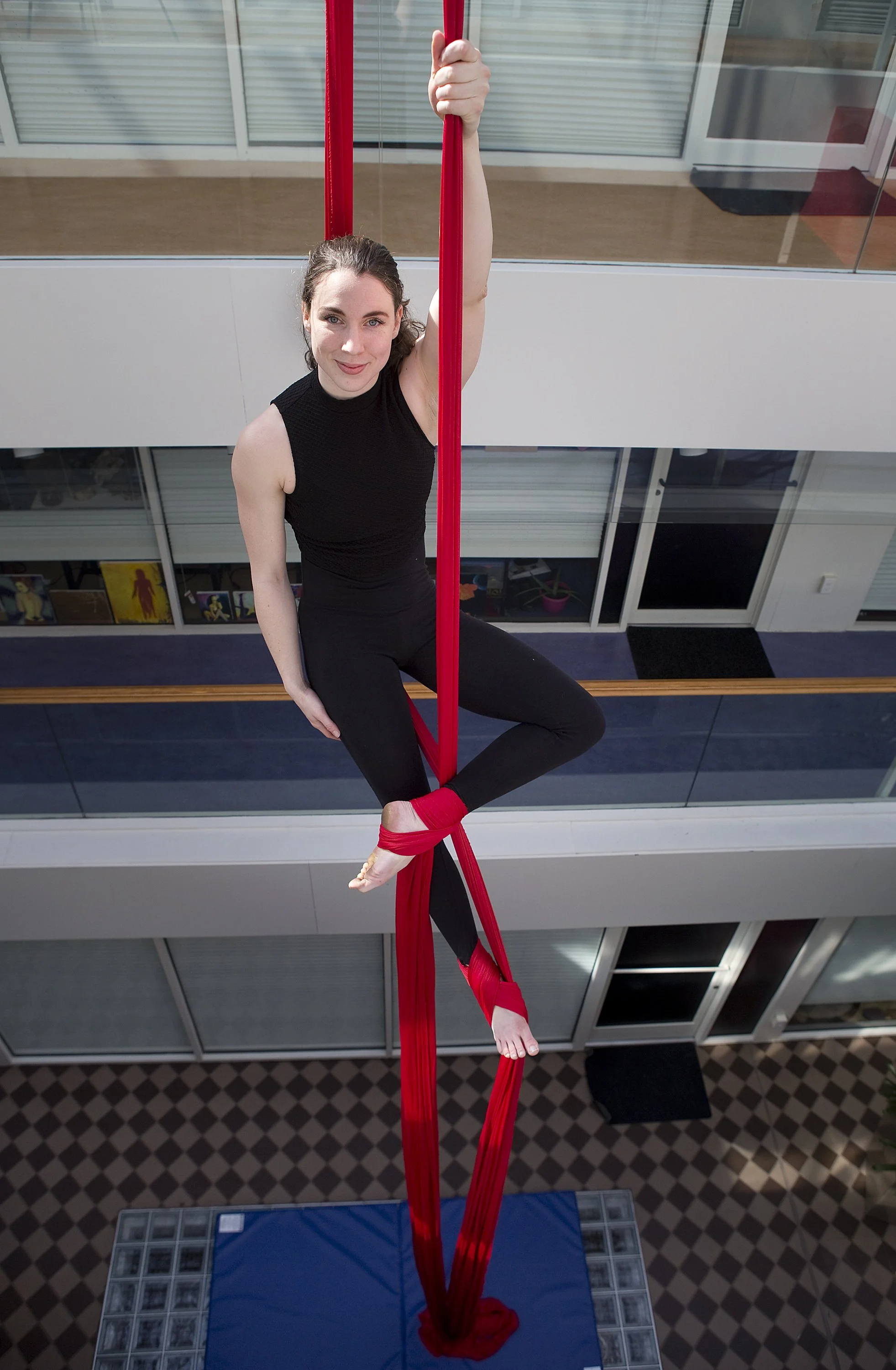  Lynsey Wyatt, 21, hangs from aerial silks in the middle of the apartment atrium at Aurora apartments on Campbell Avenue. Wyatt says the aerial fabric blend in the atrium is about 40 feet and spans the length of three floors. She has another set of a