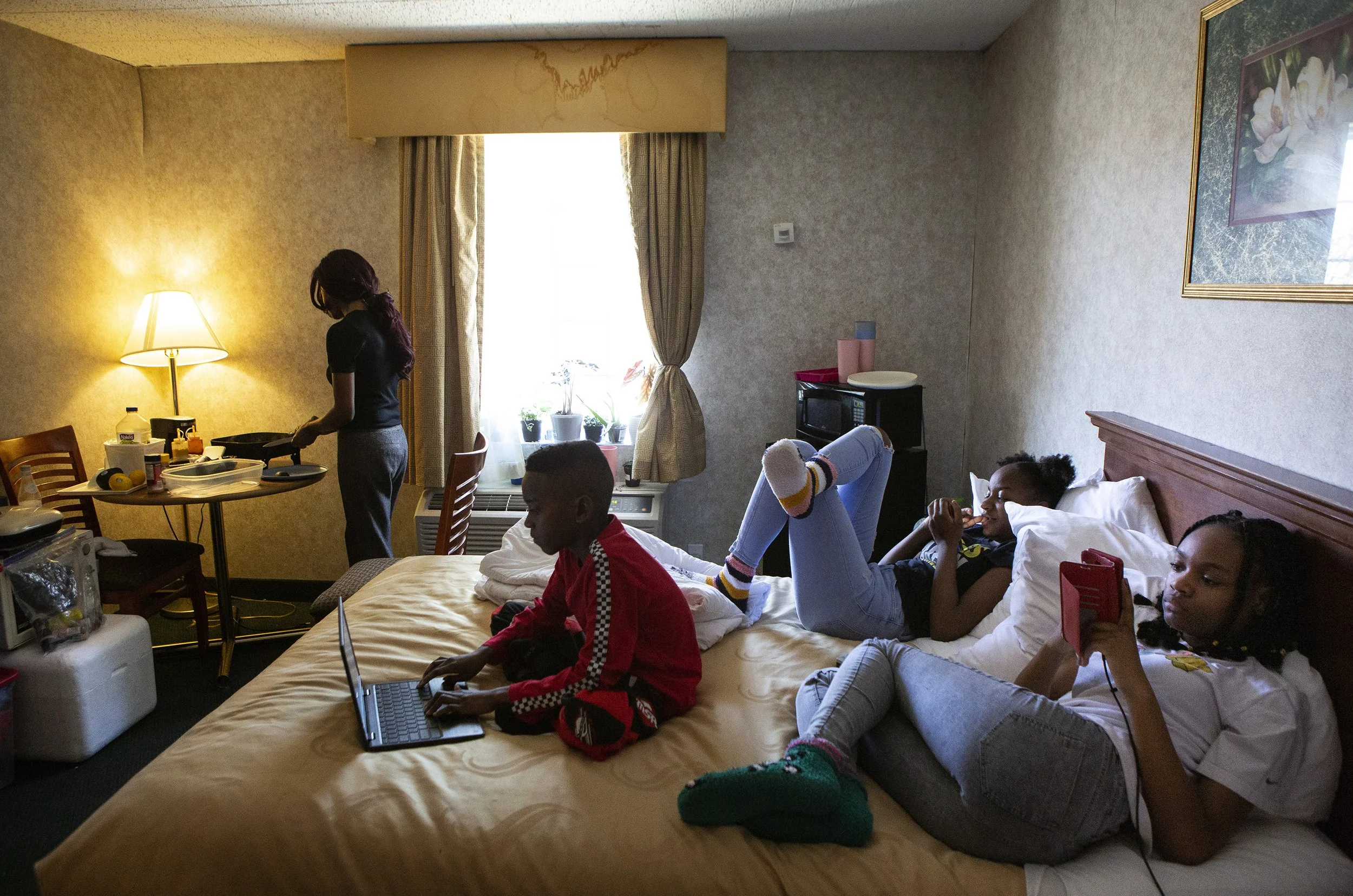  April Goode, 39, cooks hamburgers for lunch on a portable skillet for her children in a hotel room as they relax on Saturday, March 7, 2020. Goode and her children have been living at the Quality Inn in Ledgewood, New Jersey for a month now. “When y