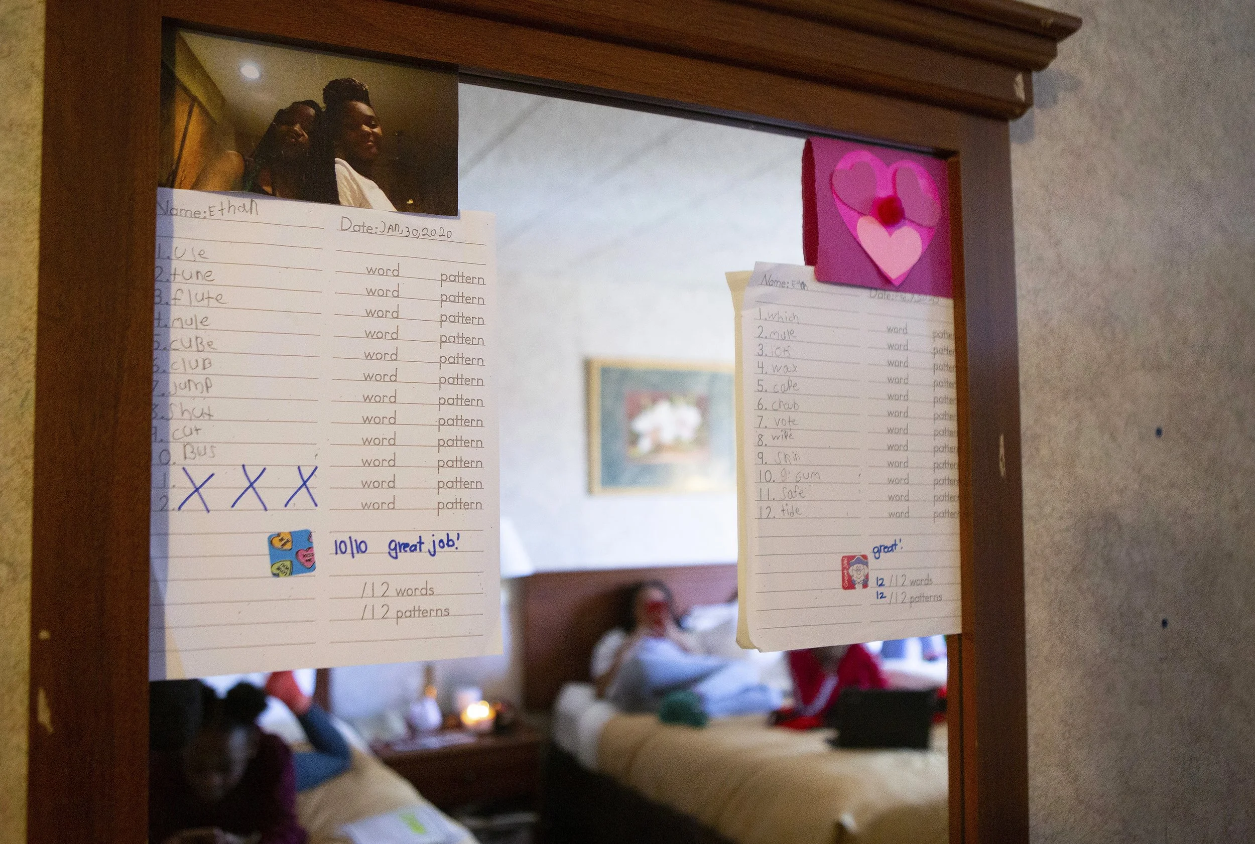 April Goode displays her son’s graded spelling tests on the hotel room furniture.  