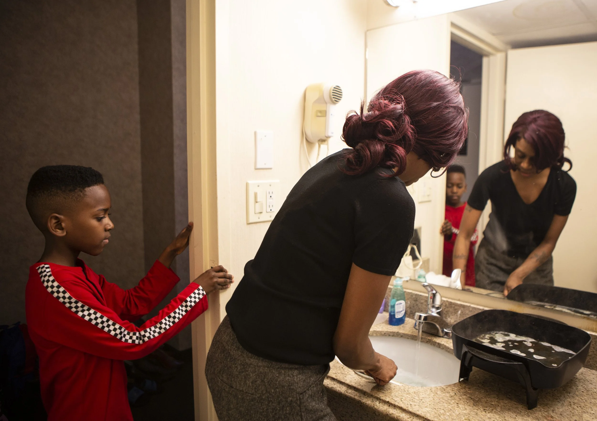  Ethan, 9, watches his mom April Goode wash the skillet in the hotel bathroom sink on Saturday, March 7, 2020. Goode and her children have been living at the Quality Inn in Ledgewood, New Jersey for a month now. “We have everything we need in this ro