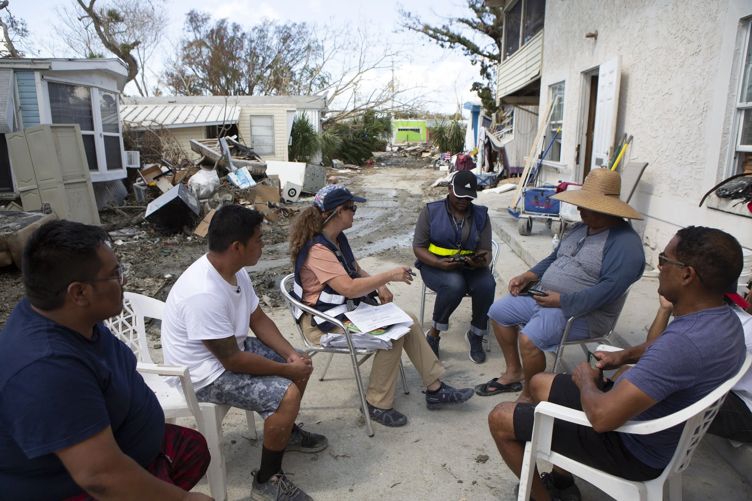  Lourdes Penagos, third from left, and Carmel Maignan, fourth from left, both with FEMA, talk to a group of residents at Sunnyland Trailer Park on San Carlos Island, Fort Myers Beach, Florida on Wednesday, October 5, 2022.  