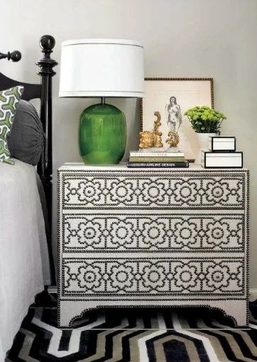The black, traditional bed pairs wonderfully with the upholstered nightstand.  
