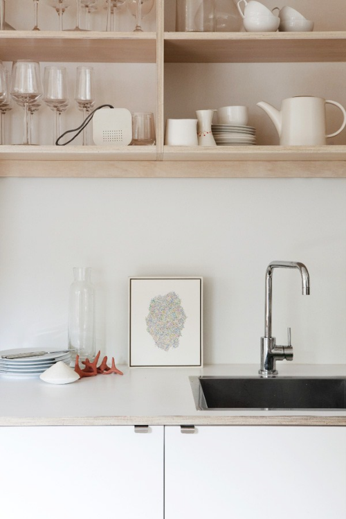 Even without a lot of extra wall space, you can still prop up a small framed piece. (via Decorator's Notebook ) 