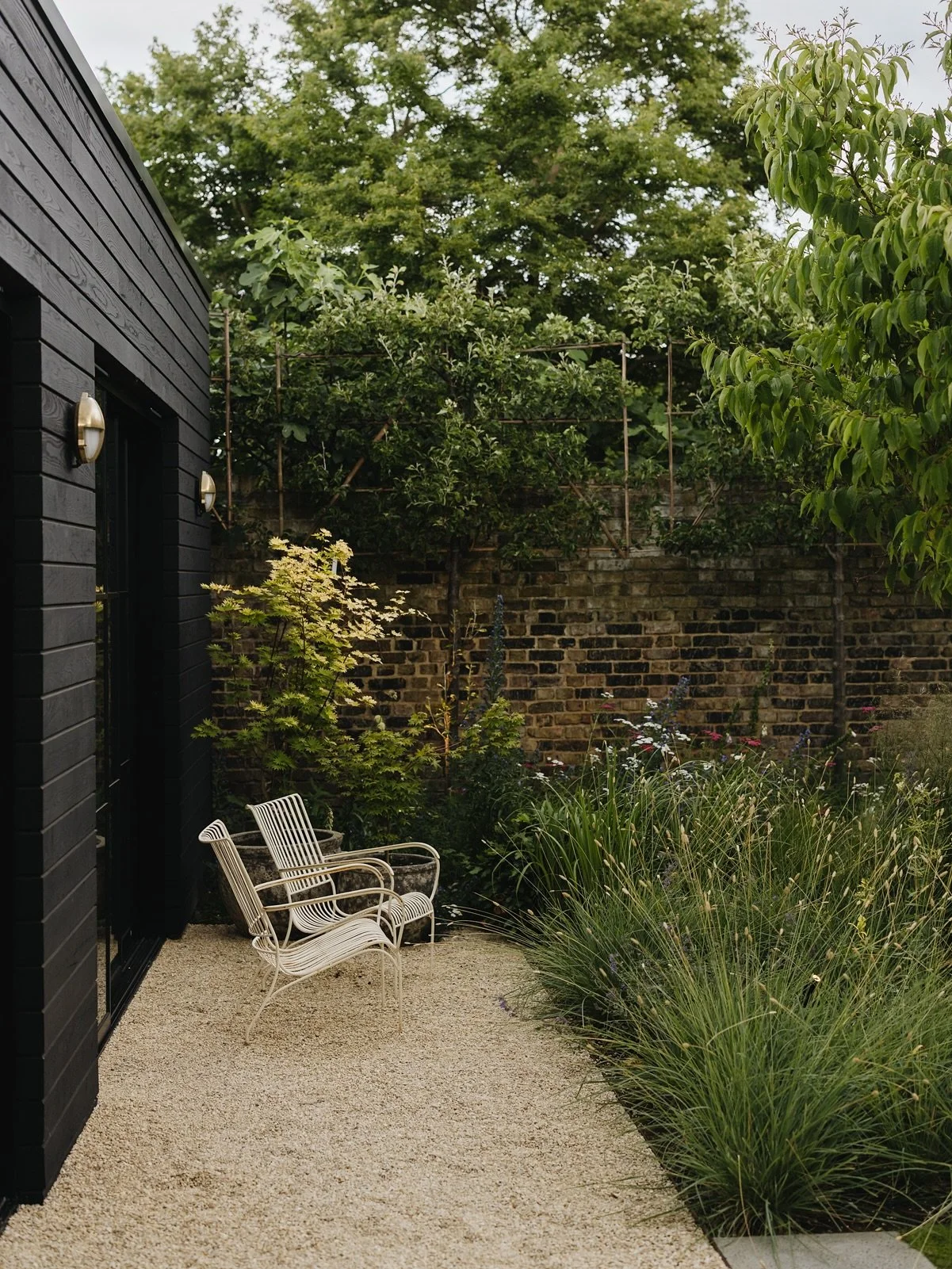 A quiet corner of our Kew project 

Beautiful lounge chairs from @petershamnurseries look onto planting with Sesleria nitida in the foreground 🌾

Design @alexandra.noble 
Build @collinsonslandscaping 
Maintenance @yuri_buckeridge 
Photography @eva_n