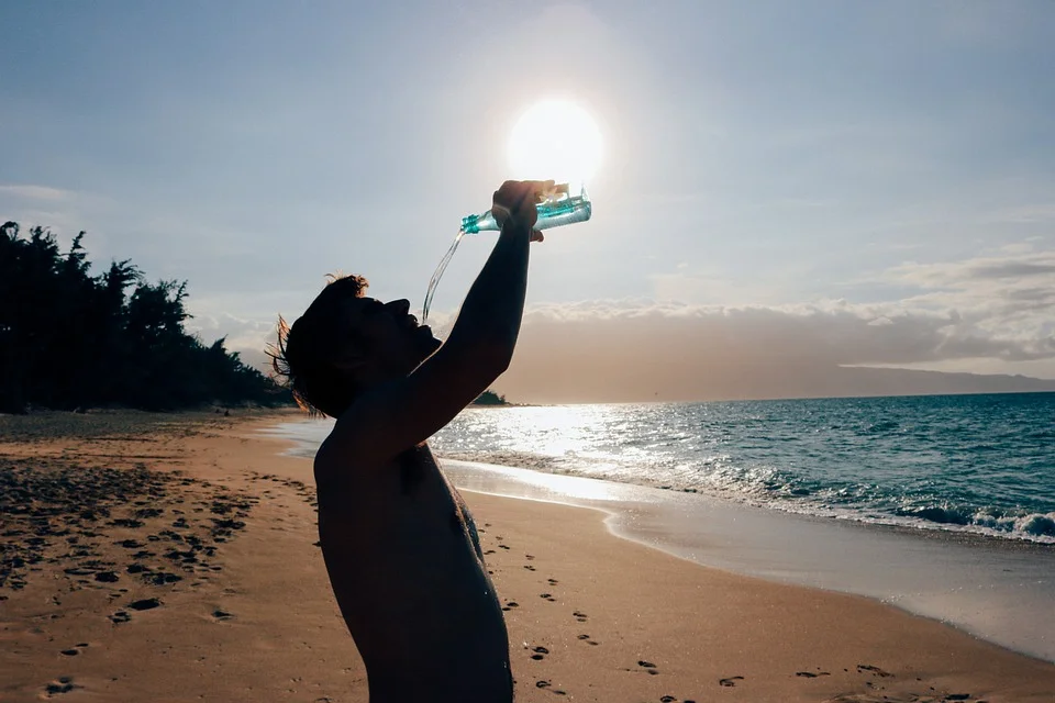 man drinking water on beach.jpg