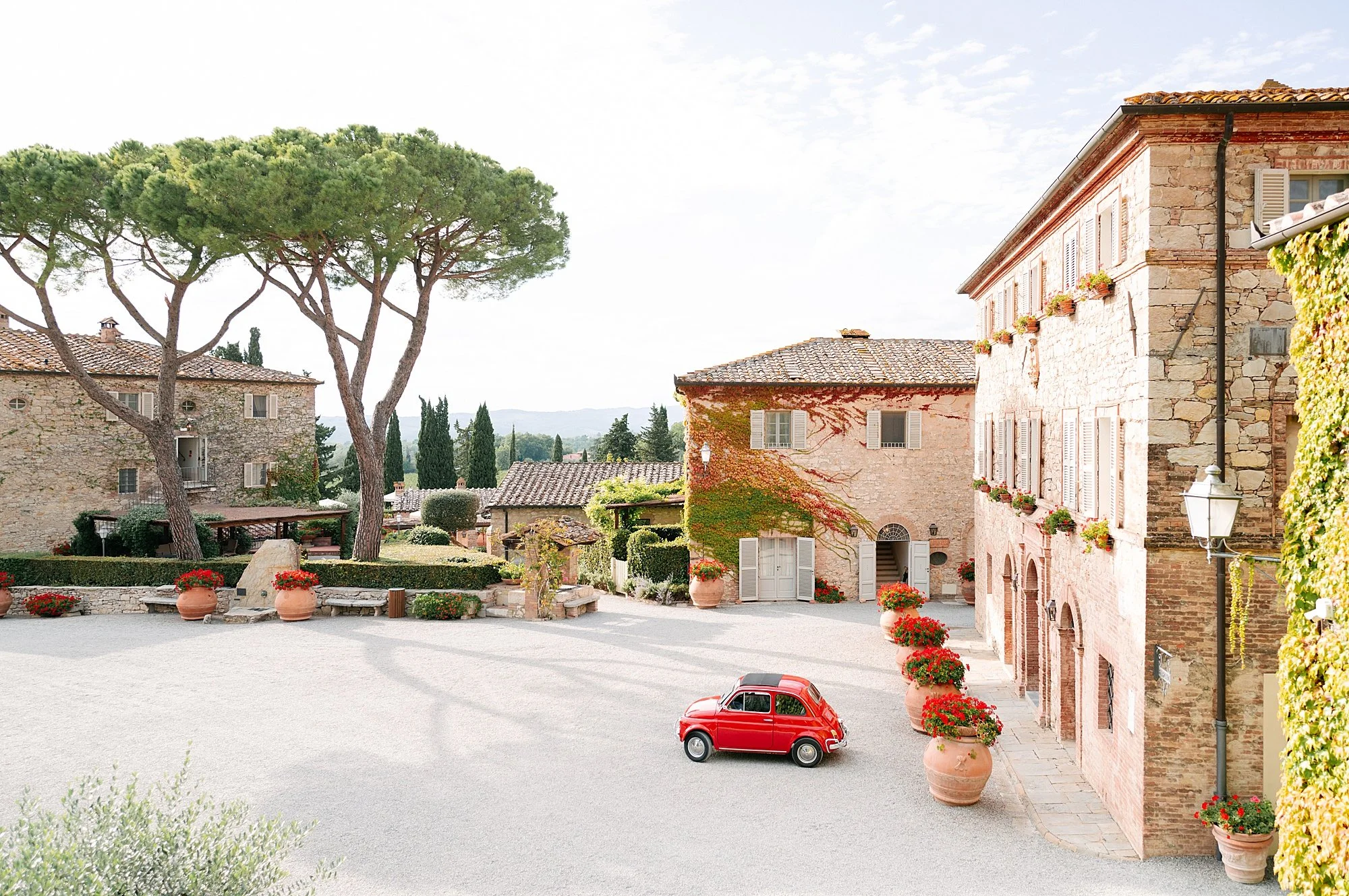Luxury wedding venue in Tuscany, Borgo San Felice, with a vintage red 500, photographed by Letizia Maccarini