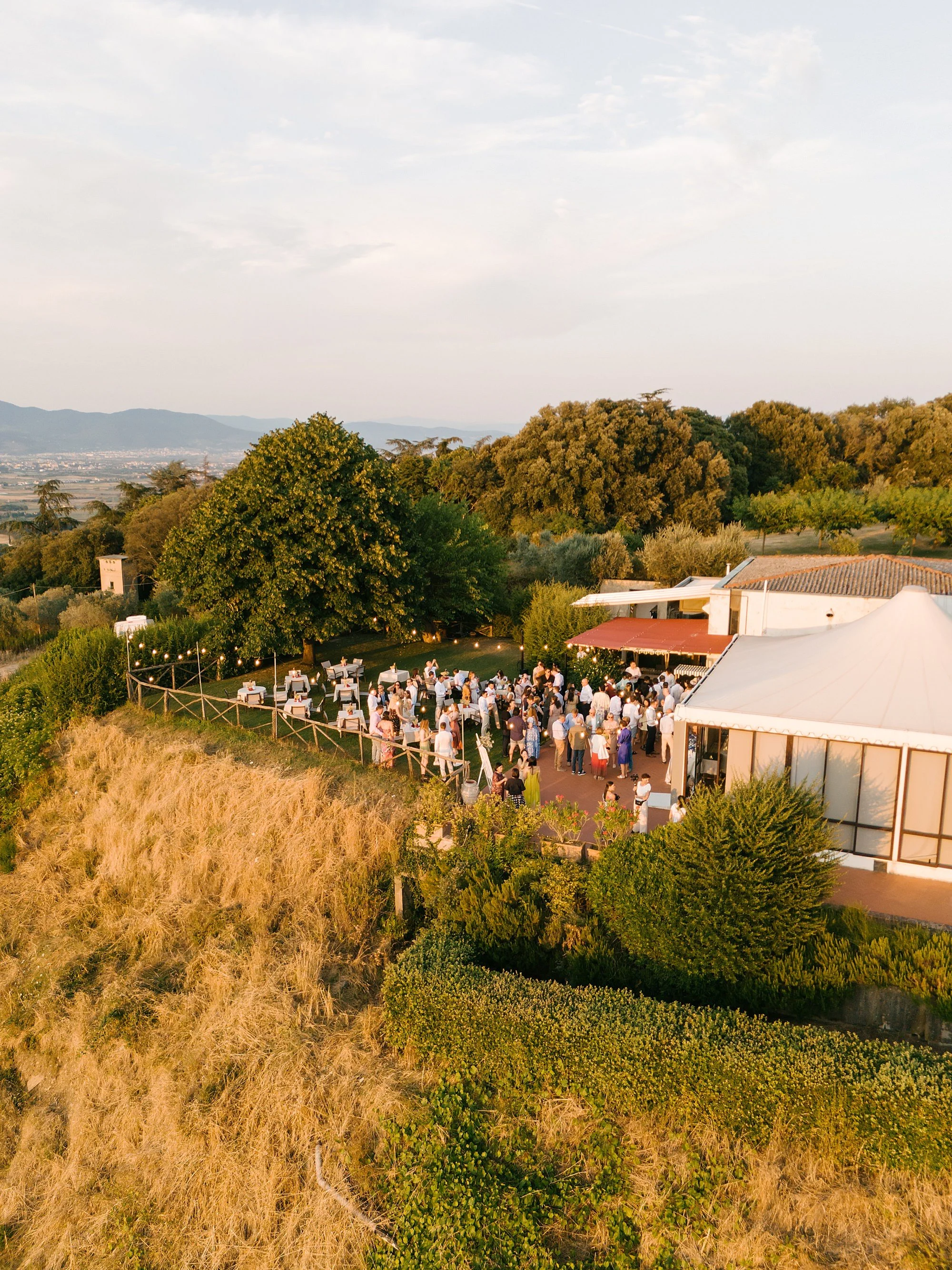 Aerial view of a destination wedding welcome party at sunset in Tuscany