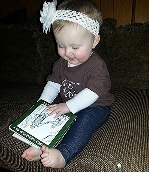 Kora Lee studies up on bowhunting while sporting our child size tee; PA