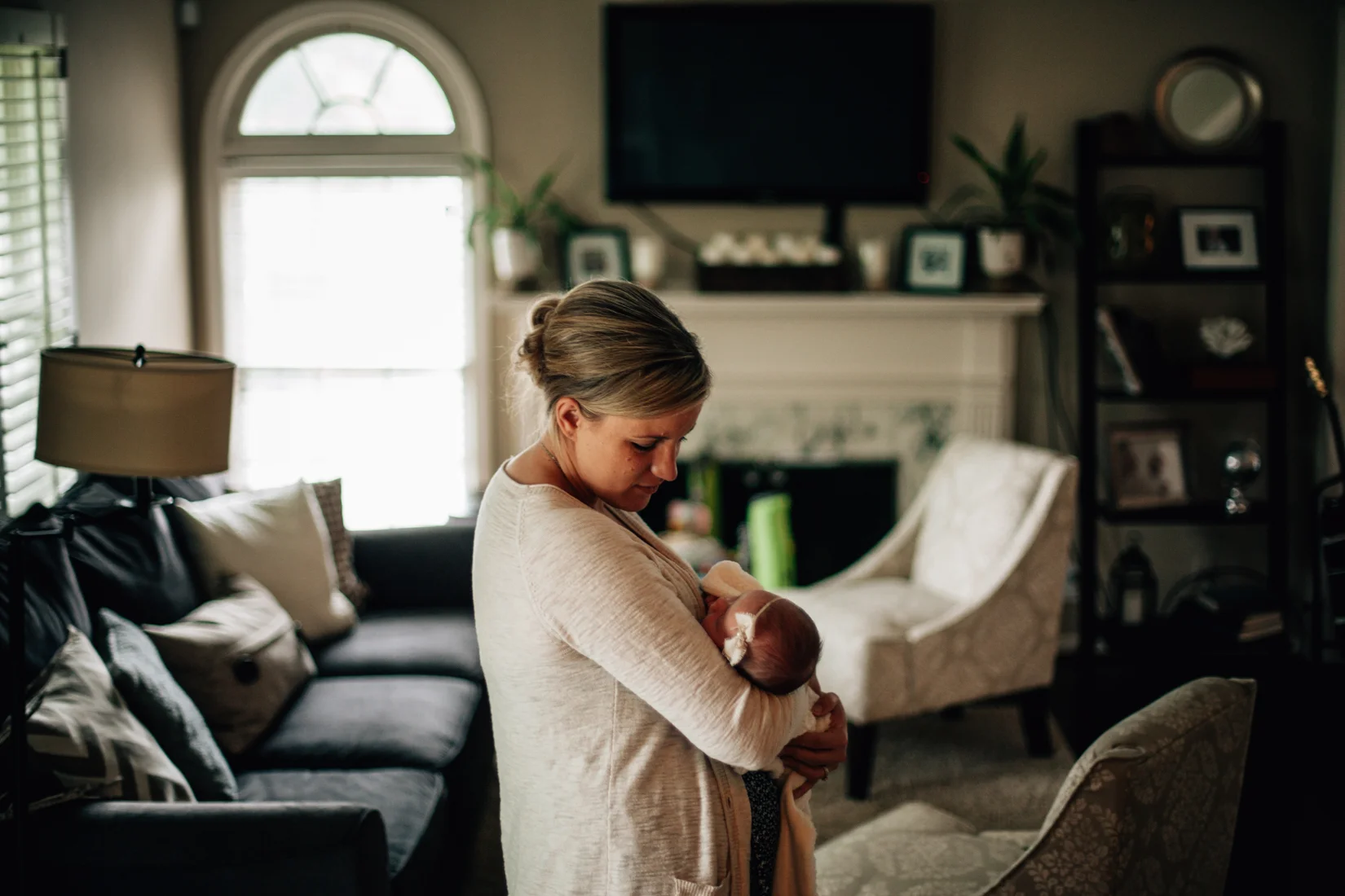 Mother holding baby in her living room