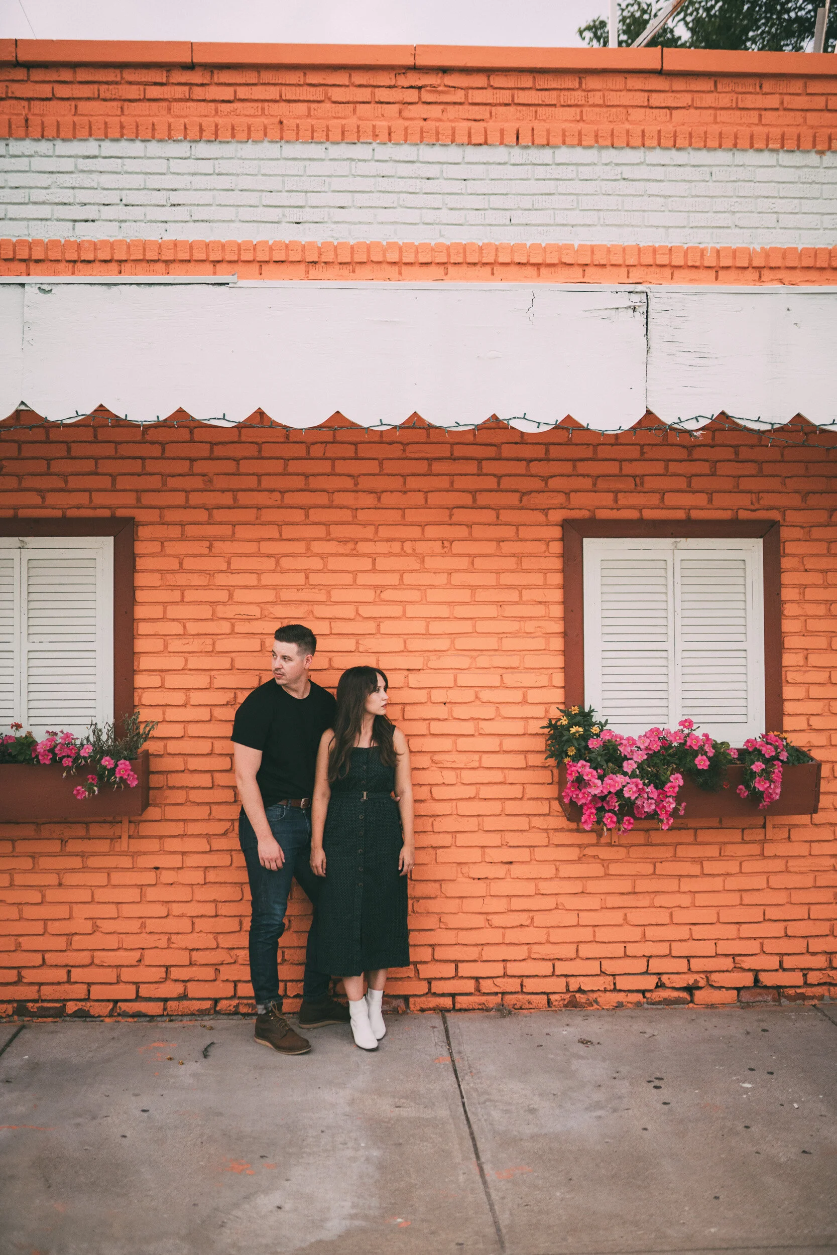 engagement session of couple in front of orange brick building