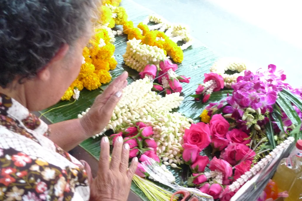 Making Sampaguita Leis in the market. Bangkok, Thailand.