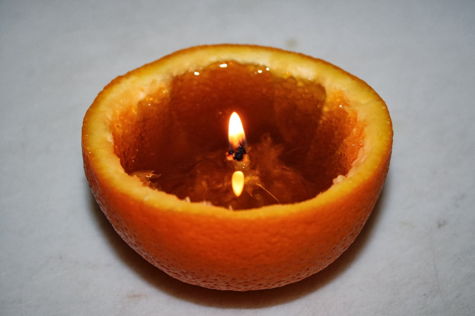 Step 1. Decide which citrus you'd like to turn in to a candle. Half a standard size lime filled with olive oil will burn for about 1 hour, while half a lemon will burn for about 2 - 2 1/2 hours, and orange filled with olive oil will burn for about 3-3 1/2 hours, and a grapefruit for 4-5 hours. Step 2. Cut your favorite citrus in half reserving the half that is connected to the long, white string-like pith that runs through the center of citrus fruits. It is very important that this remain intact and connected to the citrus, as this is your candle "wick". Step 3. You can be meticulous and remove all the flesh of the citrus down to the white pith, or you can be lazy like me and simply get most of it out. It will not affect the performance of your citrus candle. Step 4. Choose the type of oil you'd like to fill it with. Any single cultivar extra virgin olive oil, fused olive oil or infused olive oil will burn in the candle, however stay away from burning the chili olive oils such as Baklouti, Cayenne, or Harissa. Fill the citrus about 3/4 full, but make sure the wick is not fully submerged in the oil and at least 1/4" is available to light. Step 5. Gently coat the citrus pith or the "wick" with olive oil. Using a stick lighter begin the process of lighting the wick. This will take a minute or two as it is necessary to dry out the wick and char it to some degree. Once it's lit, it will stay so until all the oil is gone. 