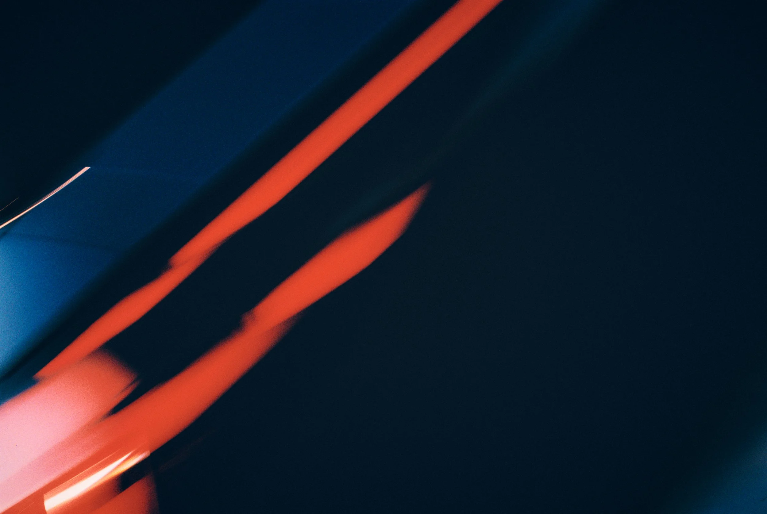 Close-up of blurred orange and blue objects against a dark background.