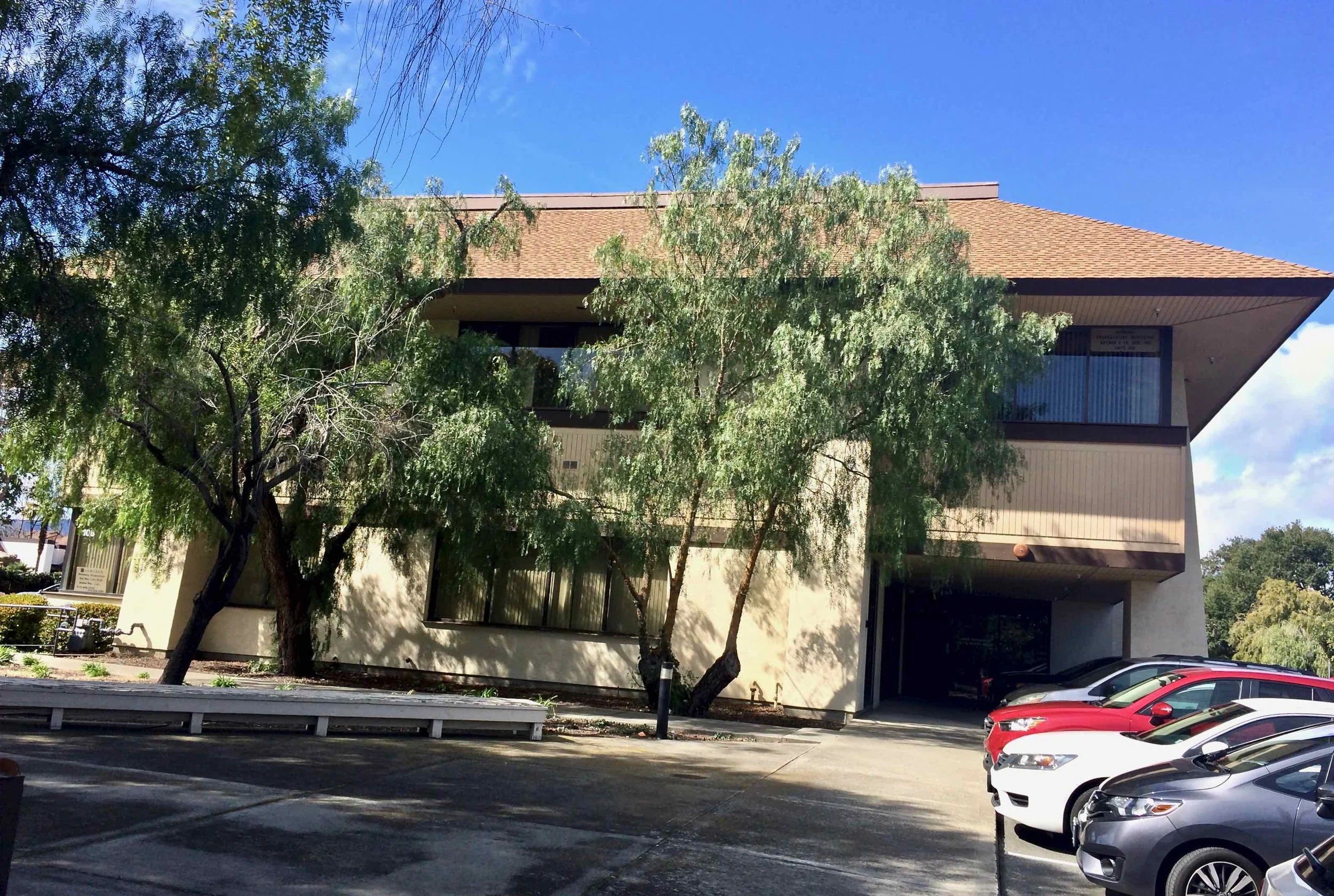 View of my office building from the street. There are parking lots and driveways on both sides of the building.