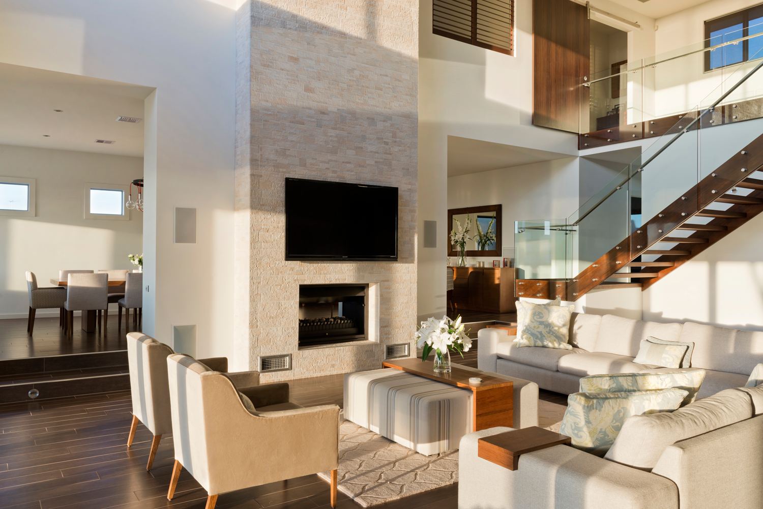 Living room with streaming sunlight and split level semi open floor-plan design.