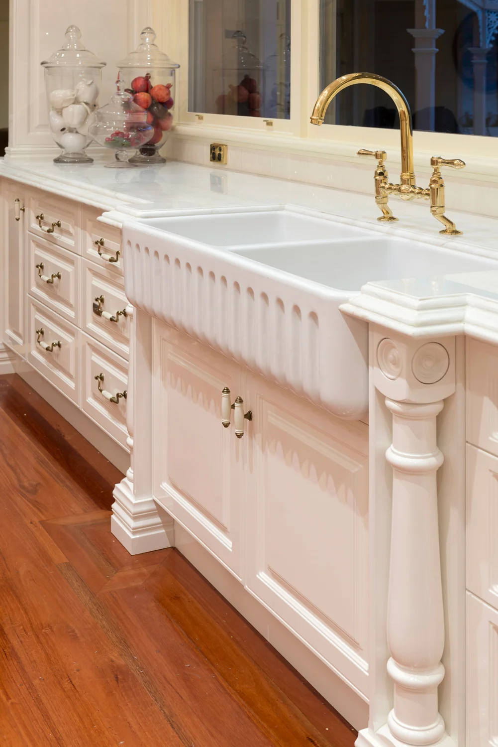 Detail image of traditional kitchen cabinetry and double porcelain sink and period fittings.