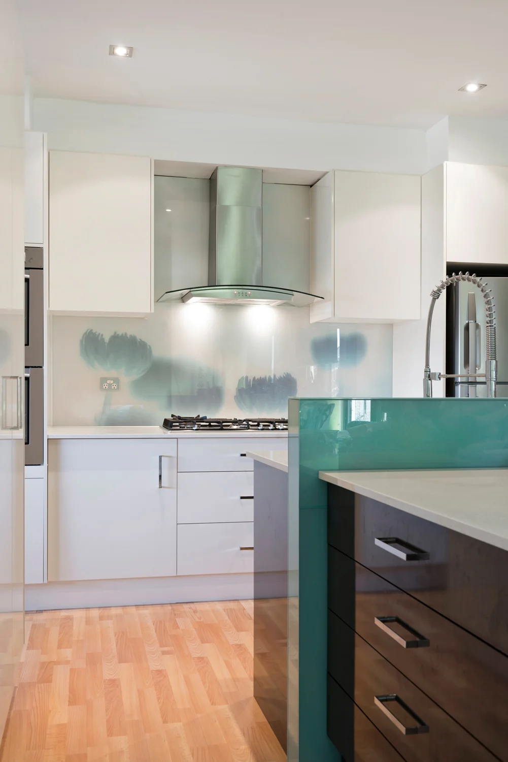 Simple design kitchen with abstract flower glass splash-back design and contemporary cabinetry.