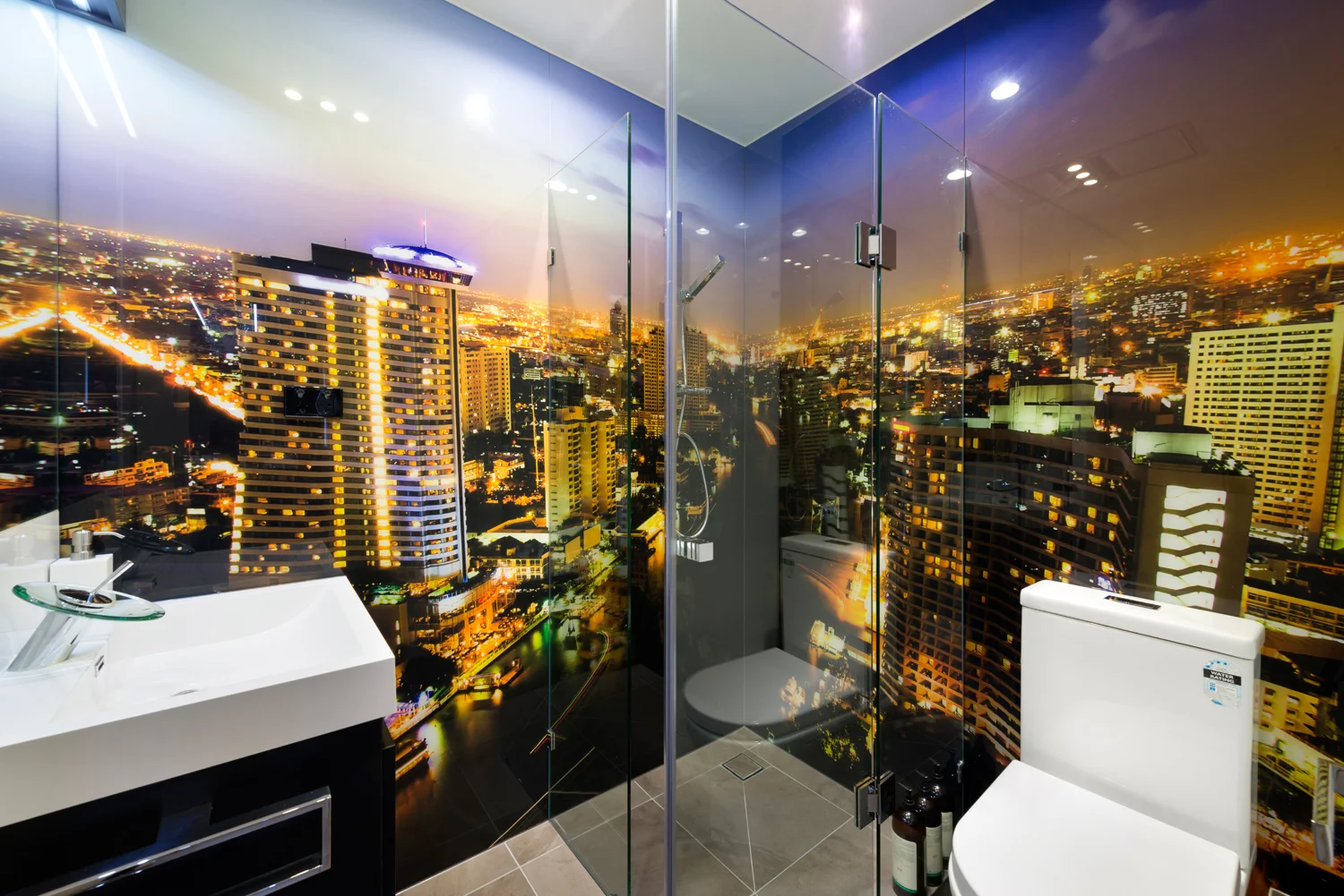 Tight space bathroom with striking glass printed large format skyline image.