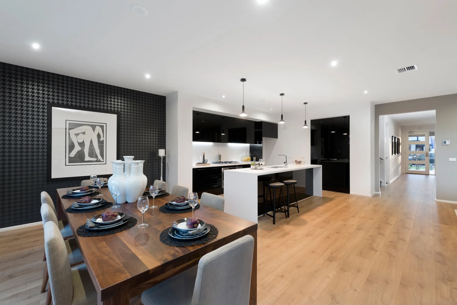 Open plan dining and kitchen layout with dark feature wall and contrast design.