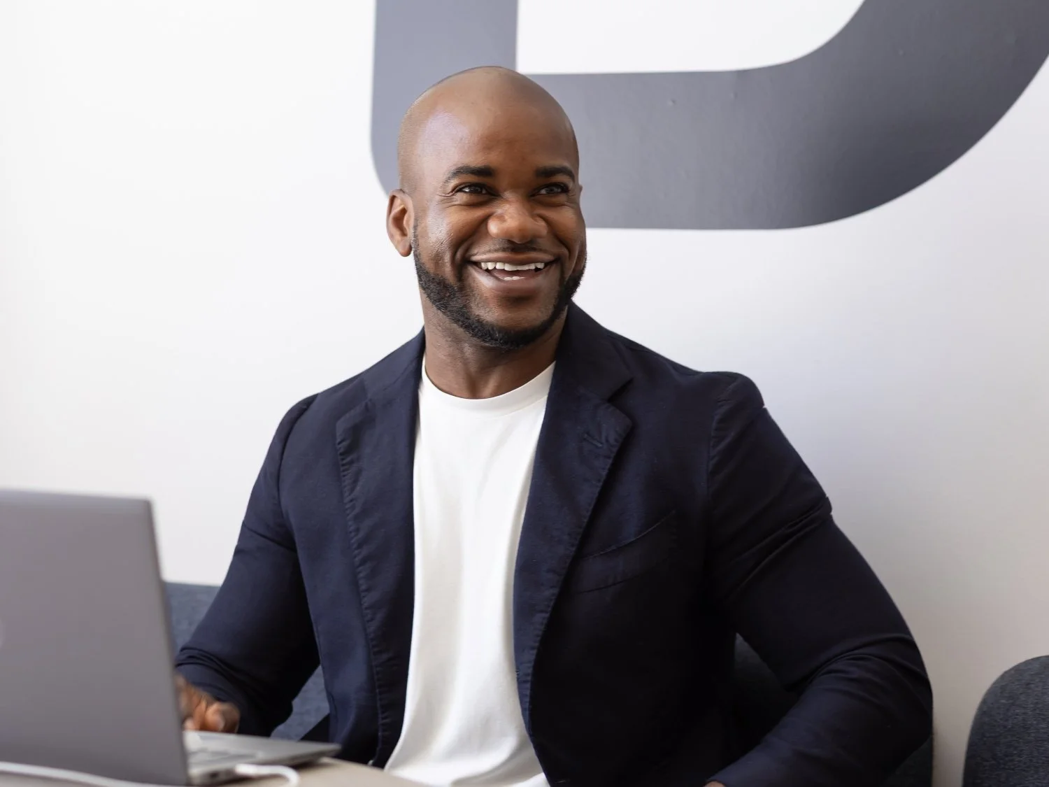  Candid fintech style corporate photography of a stylish man smiling warmly off camera 