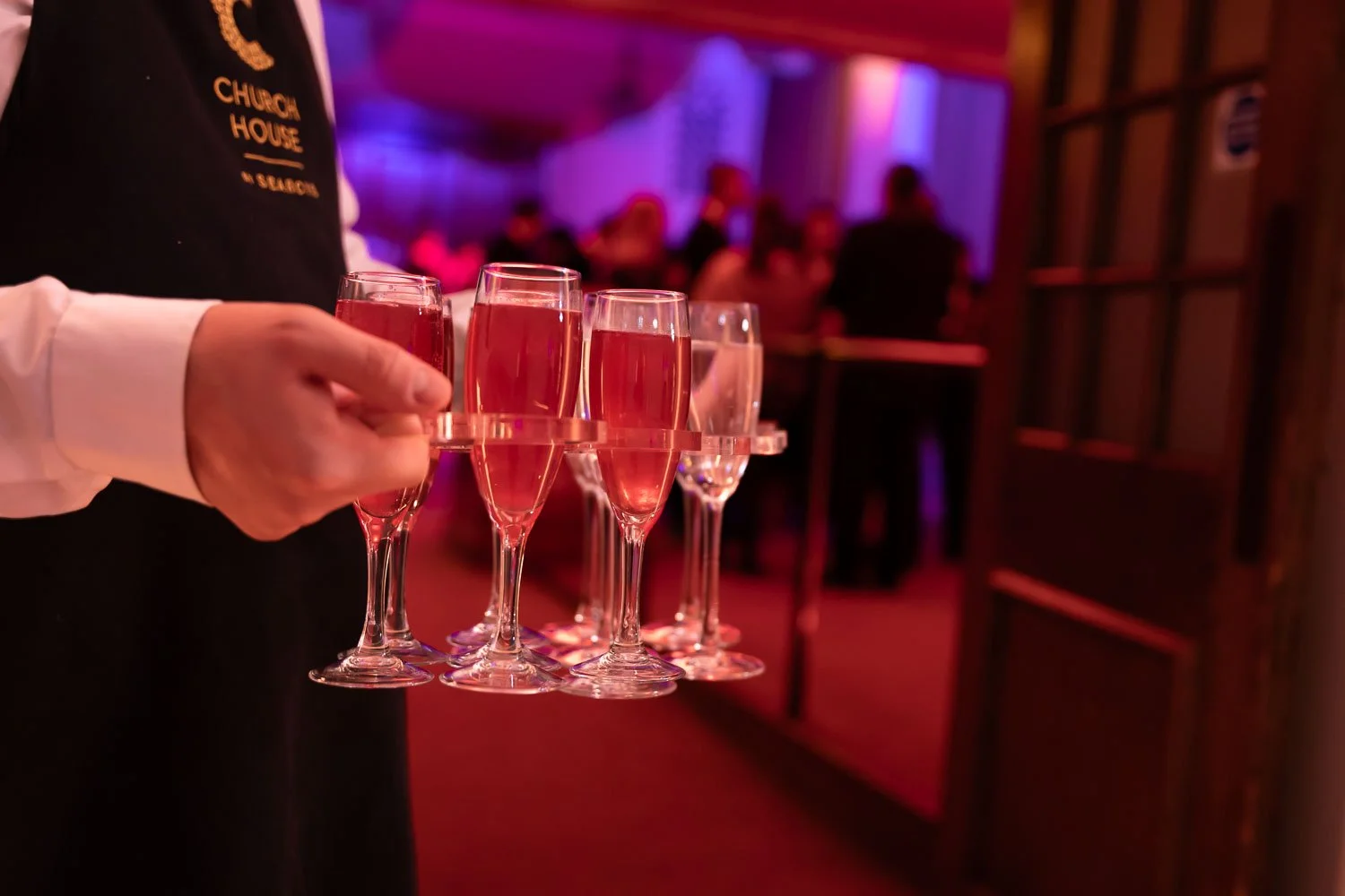  Tray of red champagne cocktails at a fancy evening party dinner event 