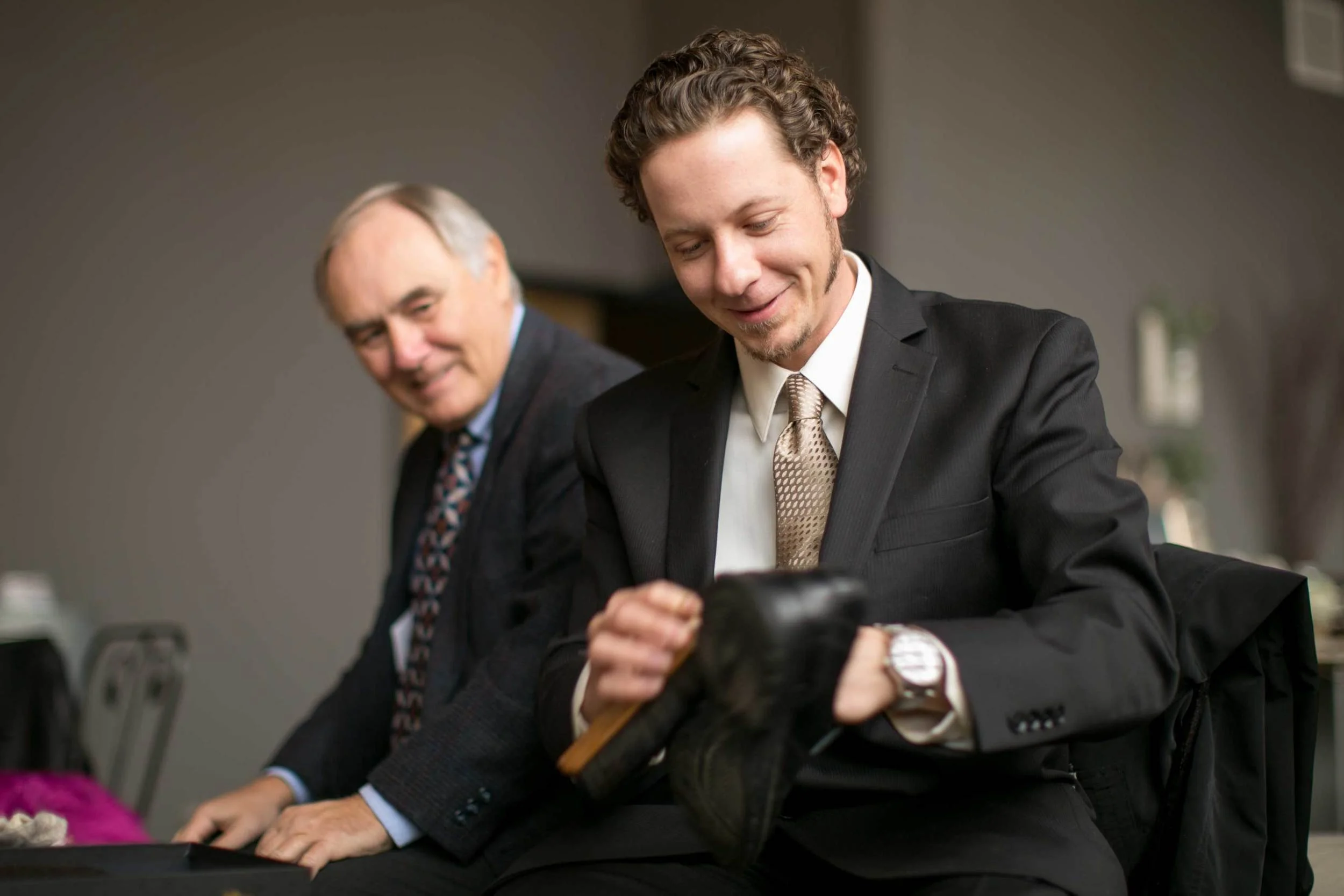 10. OUR GROOM SHARES A MOMENT WITH DAD AS HIS PUTS THE FINAL SHINE ON HIS SHOES.