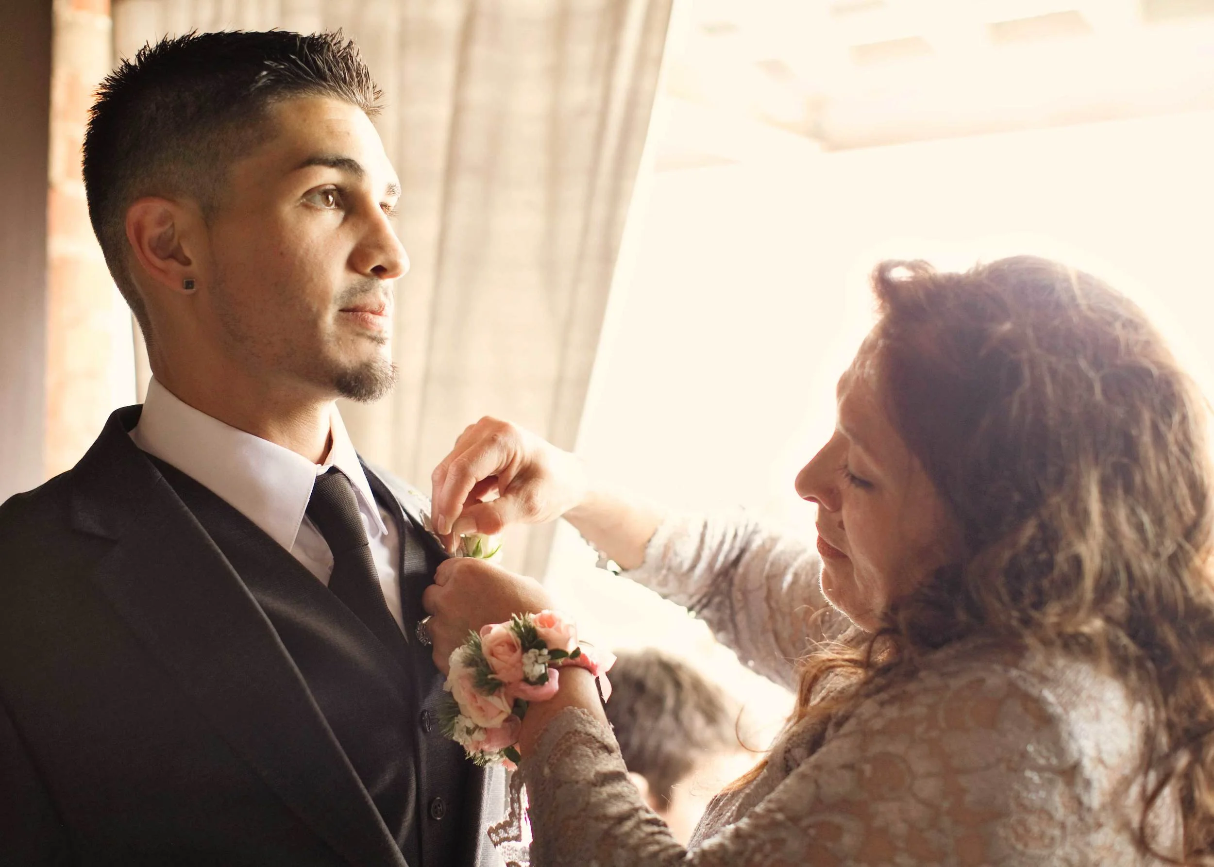 4. OUR GROOM FEELING THE GRAVITY OF THE DAY WHILE MOM PINS ON HIS BOUTONNIERE.