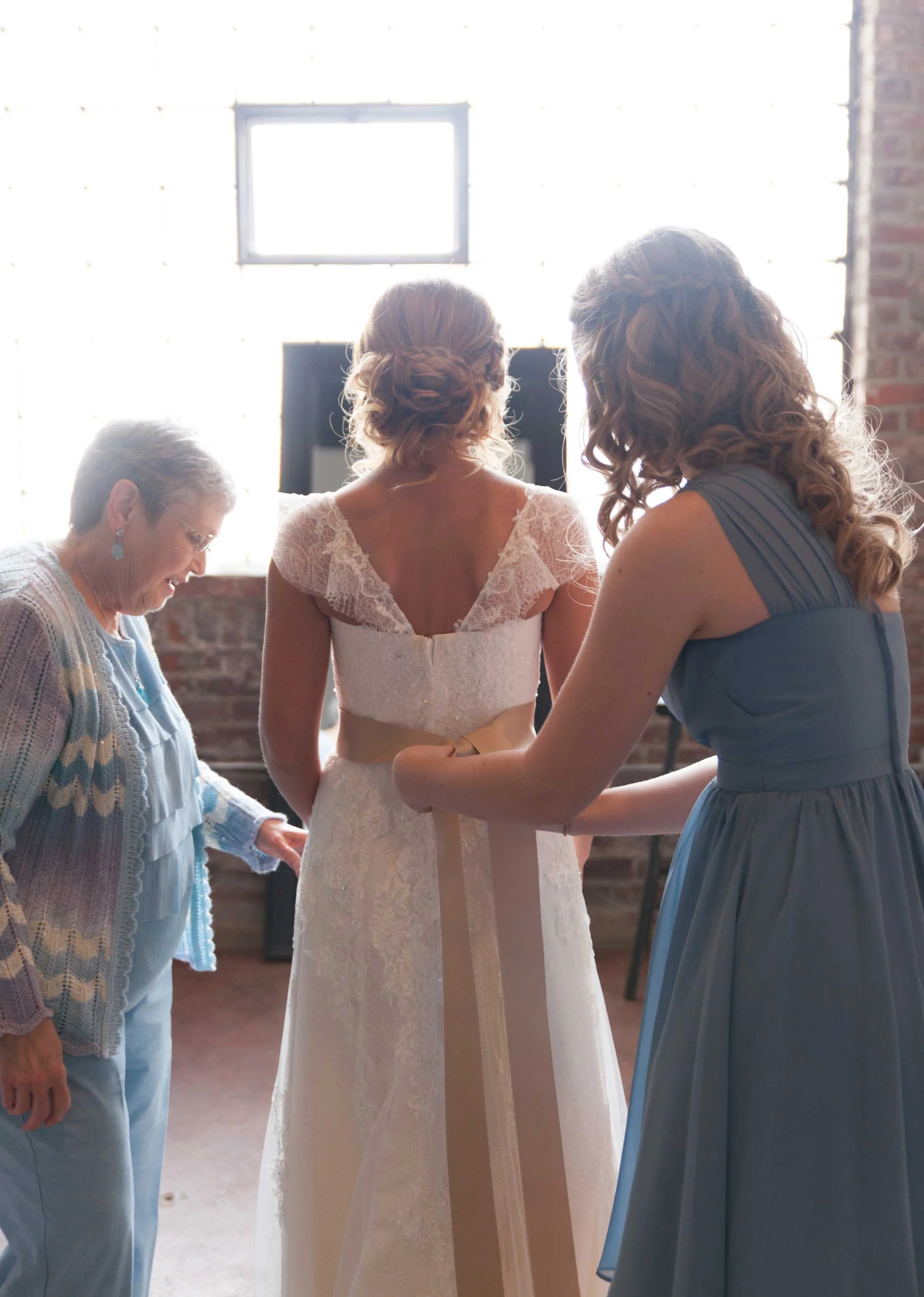 1. OUR BRIDE GETS HELP TYING HER SASH...