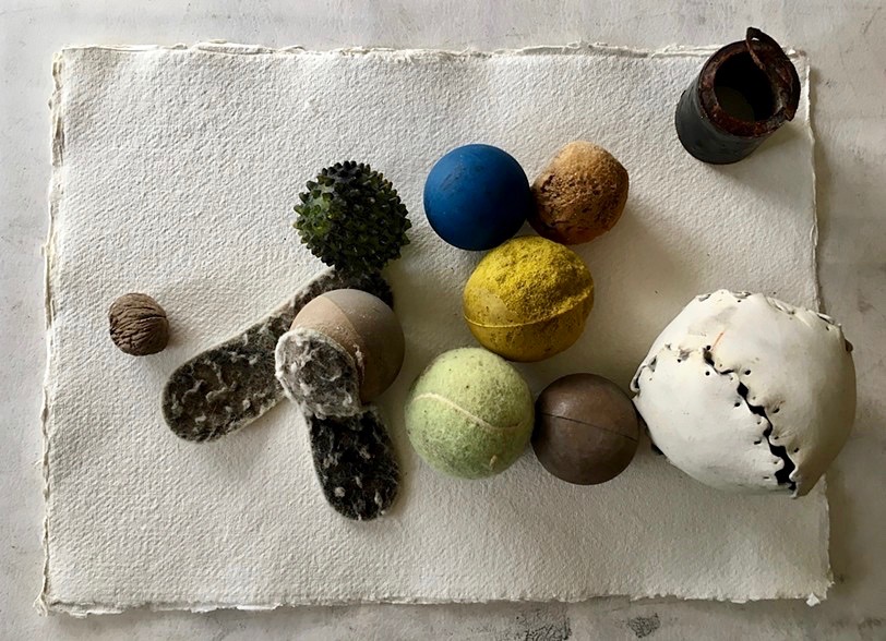 Collection of rounded objects including various balls and one walnut found in rocks surrounding Governors Island.
