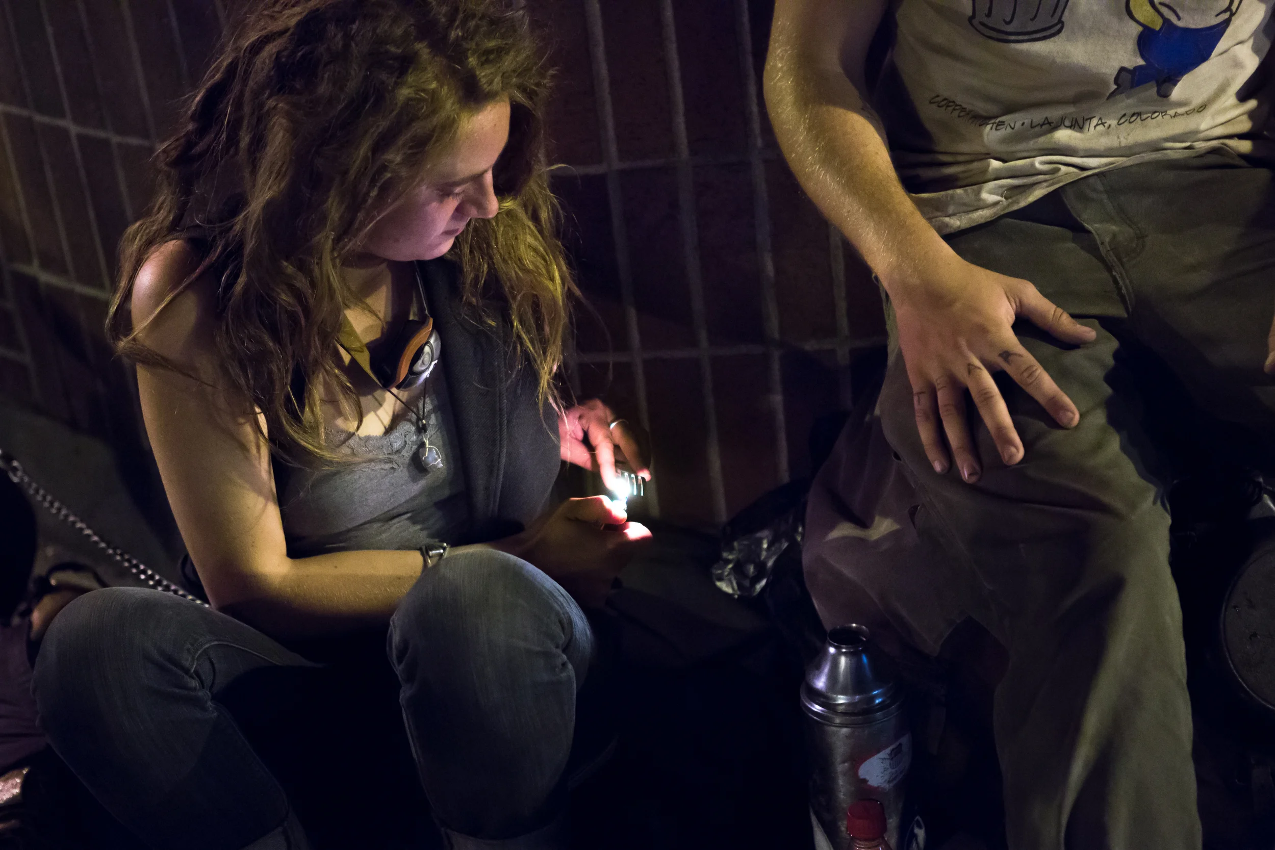 A 20-year-old homeless woman who asked to be identified as Toby uses a flame from a lighter to clean a fork she would later use to eat noodles. She had been asking pedestrians for money and alcohol outside Blanchard's liquor store in Allston, Mass. Photo credit: Justin Saglio