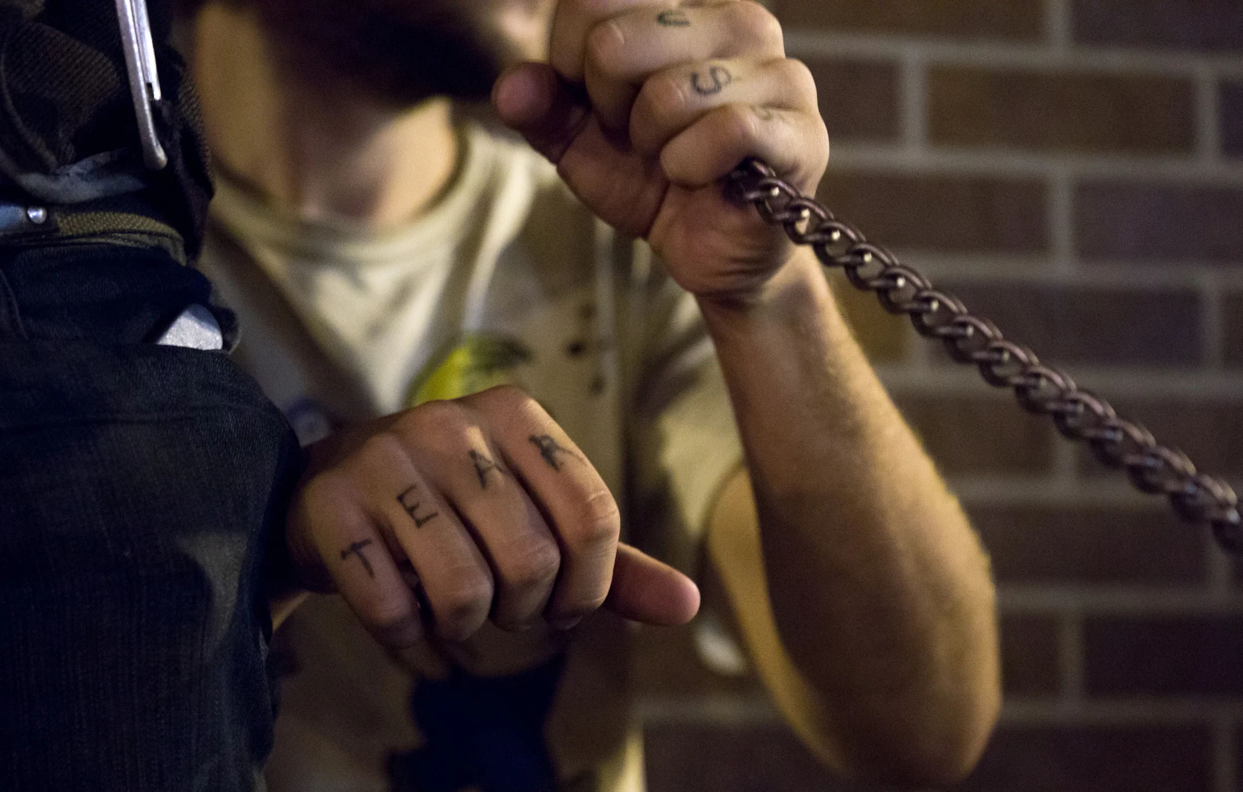 A 20-year-old homeless man who asked to be identified as Anchor grabs a chain attached to the pants of his girlfriend, also homeless, who asked to be identified as Toby as they sit outside Blanchard's liquor store in Allston. "I am perfectly content," Toby said. Photo credit: Justin Saglio