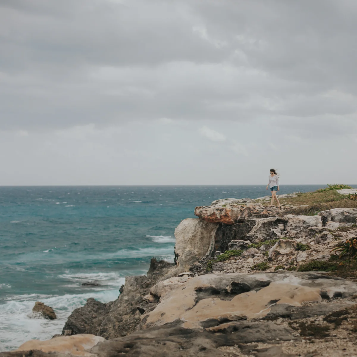 Woman strolls along the coast of Punta Sur in Isla Mujeres, Mexico. 