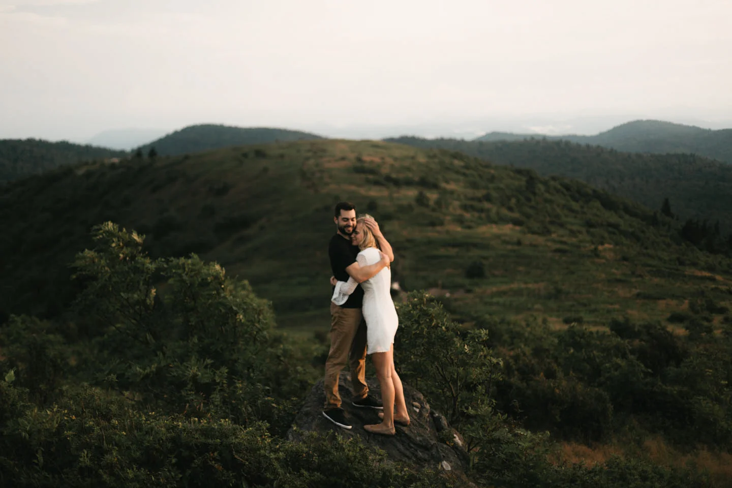 Man and woman embrace on the Blue Ridge Parkway in North Carolina.