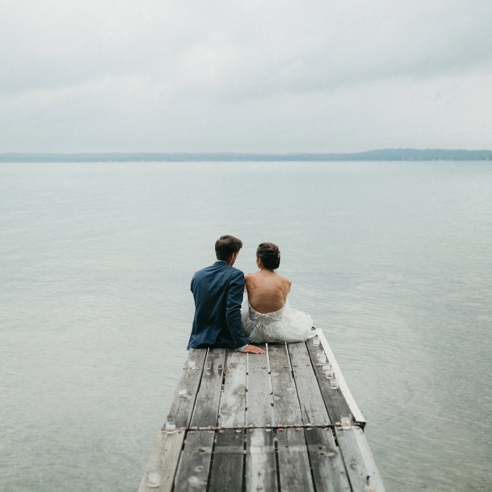 Bride and groom on a dock on Elk Lake, Michigan.
