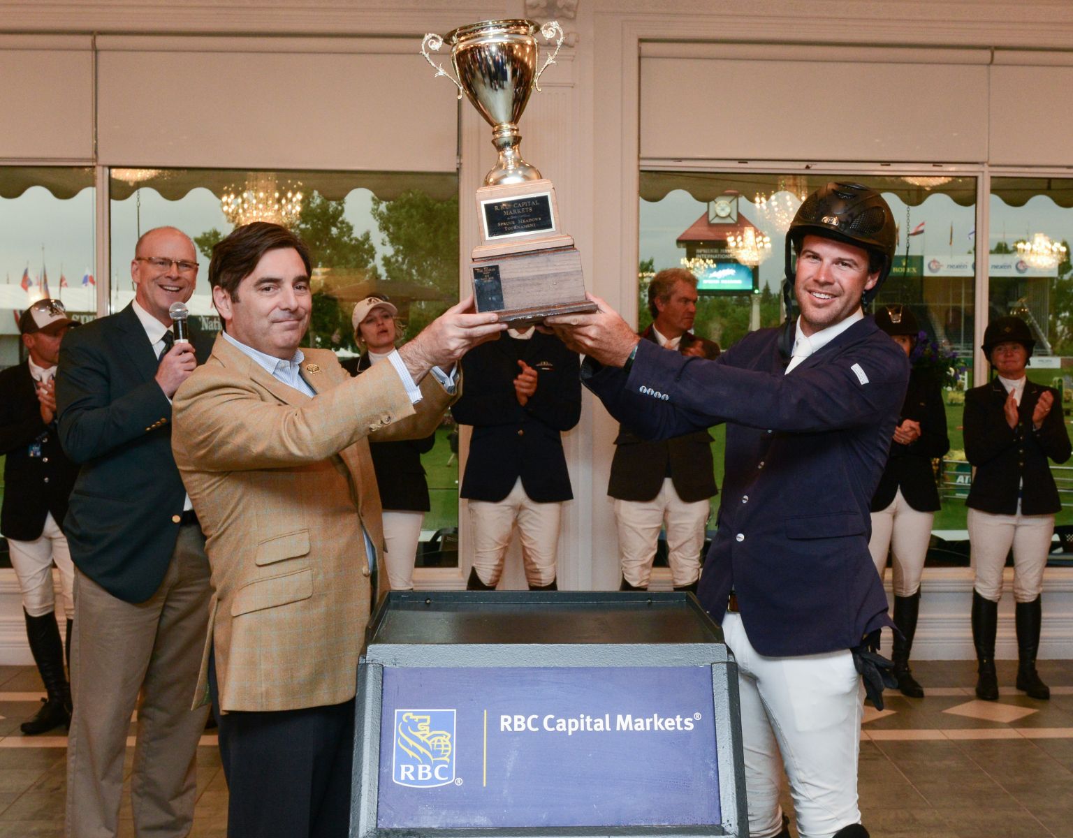 Hardin Towell hoists the championship trophy with David Dal Bello, managing director at RBC Capital Markets during the awards ceremony. 