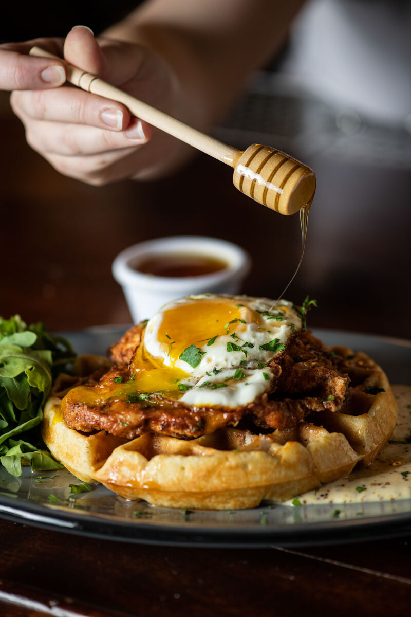 Honey drizzled on Chicken &amp; Waffles topped with a fried egg &amp; honey