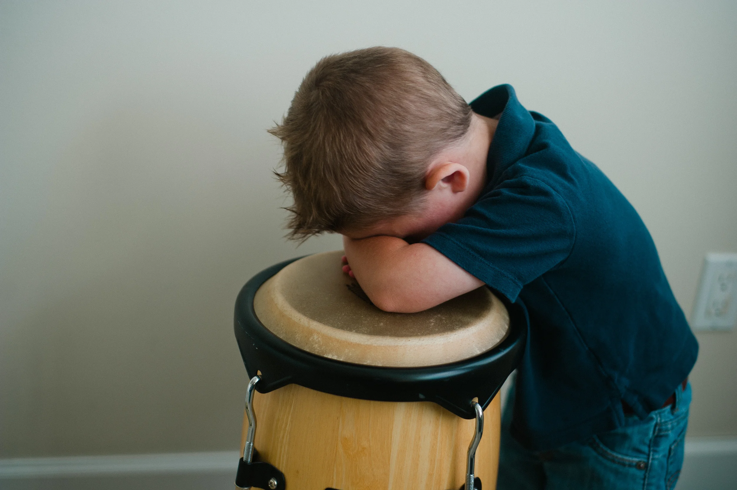 Child with head down on drum