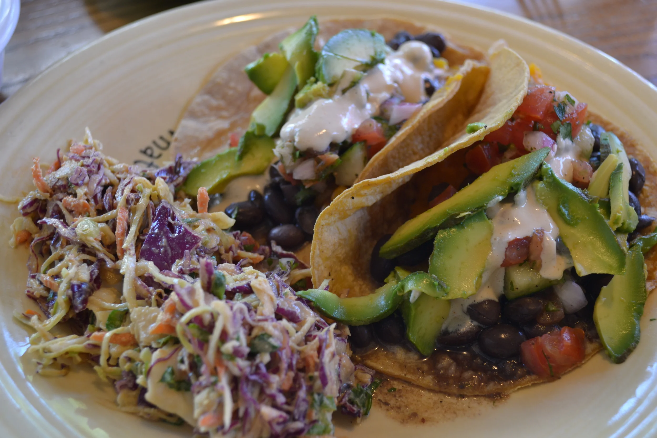 TRANSFORMED by two corn tacos stuffed with butternut squash, black beans, avocado and more, with a side of Mexican coleslaw.