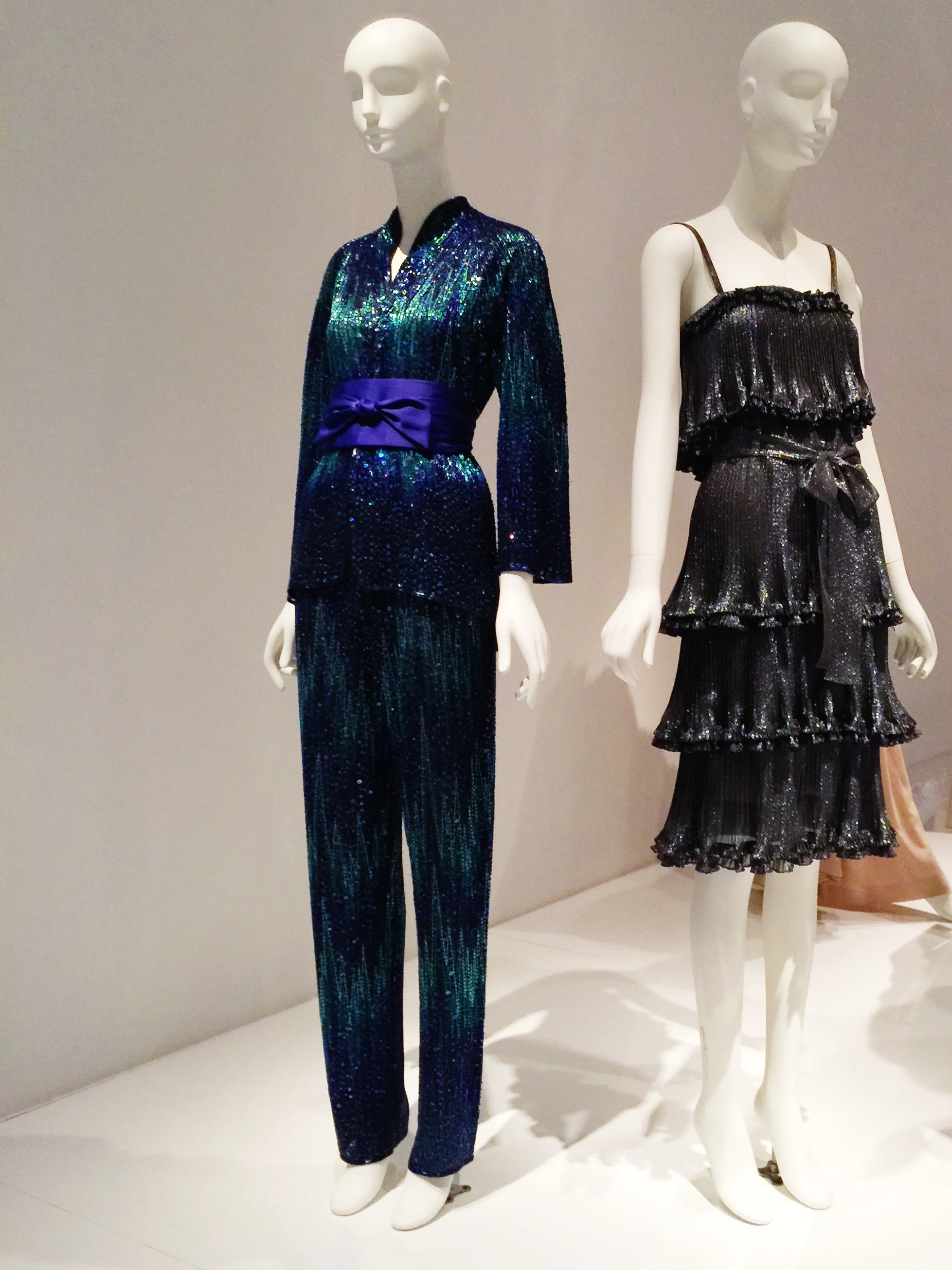 Left to Right Halston Blue and green evening ensemble, beaded silk organza, circa 1981, New York Yves Saint Laurent Black and silver dress, lamé, 1973, Paris