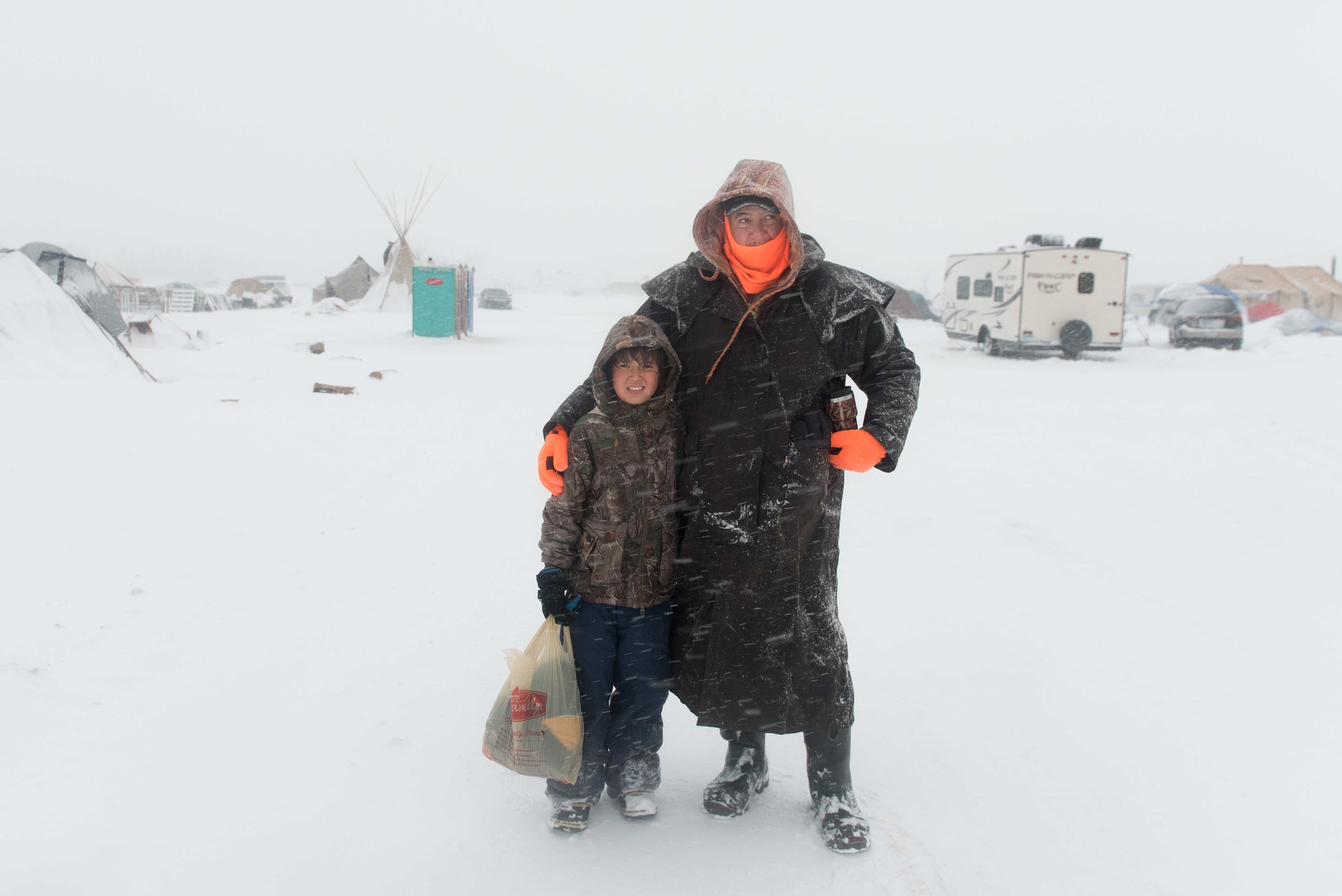  Richard Ray, a bee keeper from Quebec, and his son, Richard Ray, Jr., 8, walk to take a bath at the Oceti Sakowin Camp, the largest of the Standing Rock encampments near Standing Rock, North Dakota where  people who call themselves water protectors 