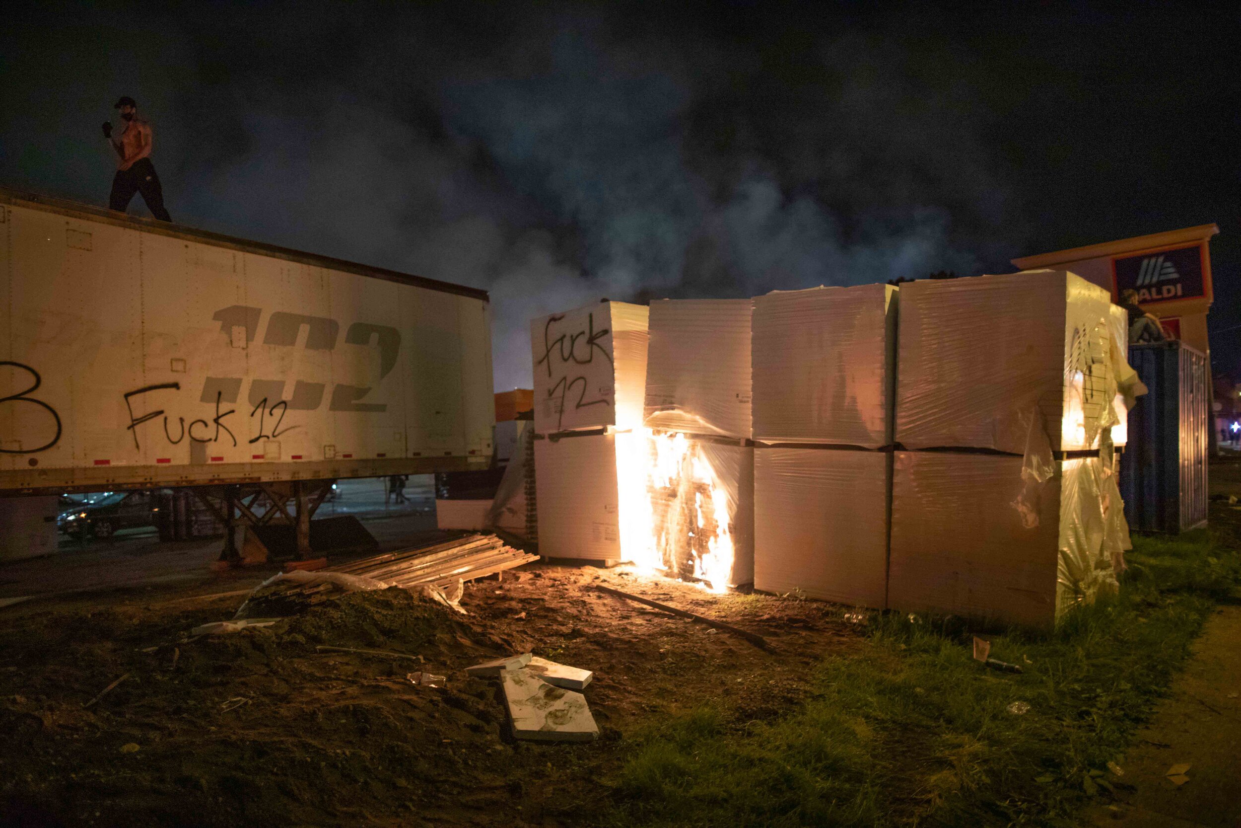  A man walks on top of a semi trailer after a crate of what appeared to be wood was set on fire during a riot in Minneapolis, Minnesota over the police killing of George Floyd on May 27. 