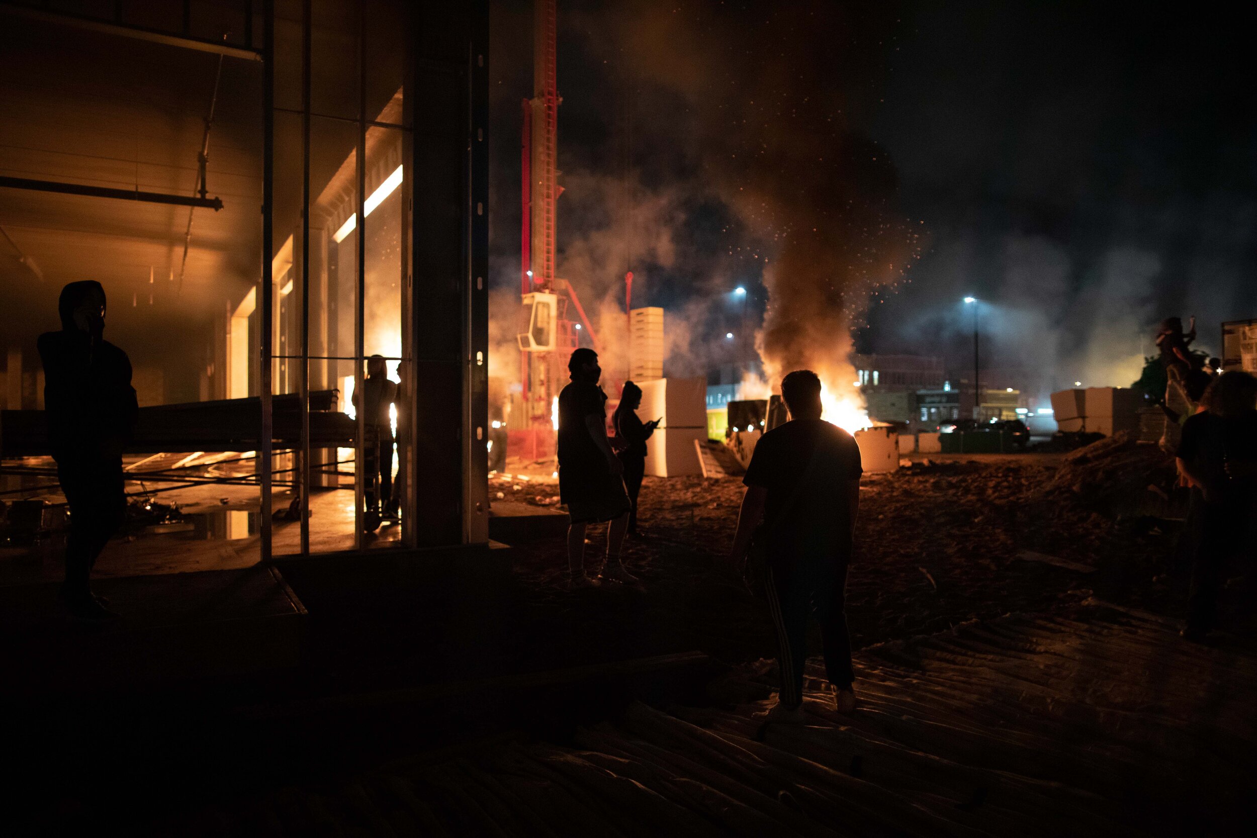  After a construction site was set on fire durign a riot over the police killing of George Floyd, protesters walk on the grounds of the building which was set to be a 190 unit, low income housing in Minneapolis, Minnesota on May 27. 