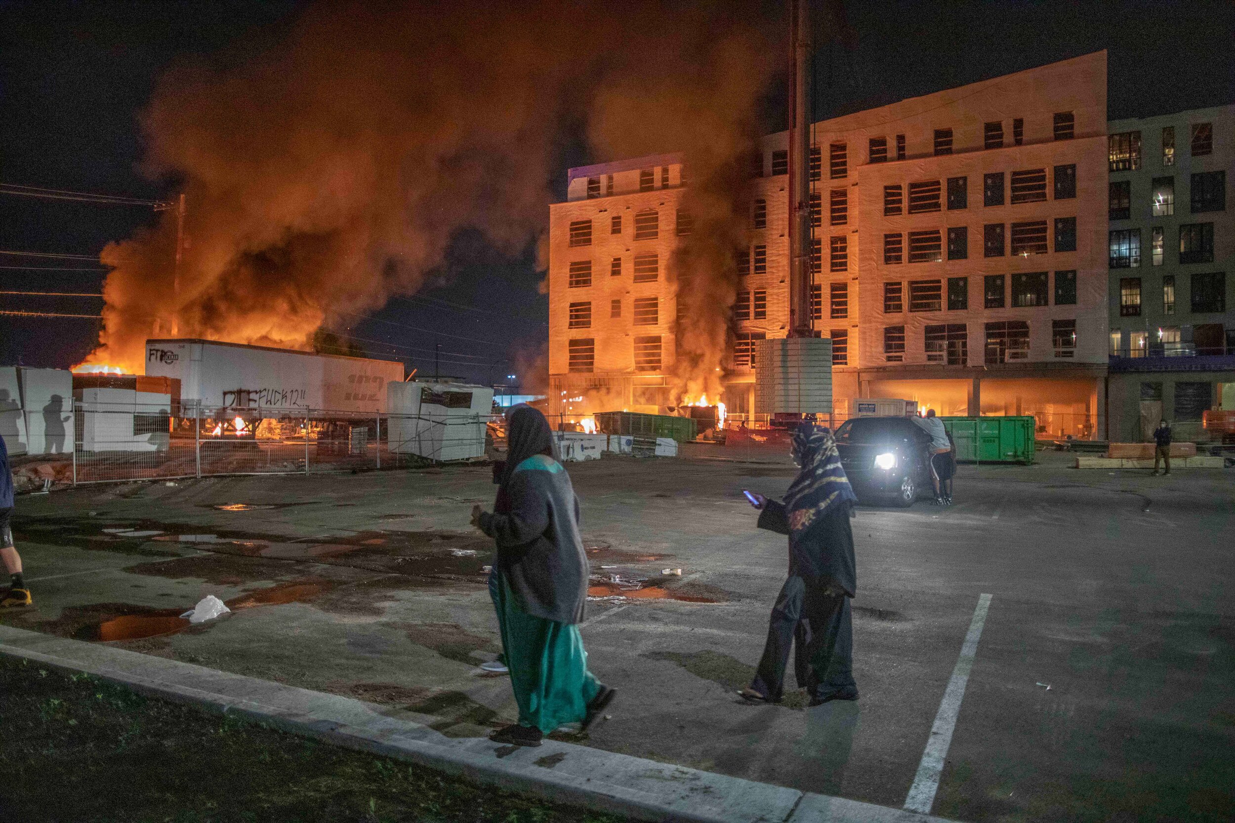  Women walk across the parking lot of what was supposed to be a 190 unit affordable housing in Minneapolis, Minnesota on May 27. The construction site was set on fire during a riot over the police killing of George Floyd.  The building was a complete