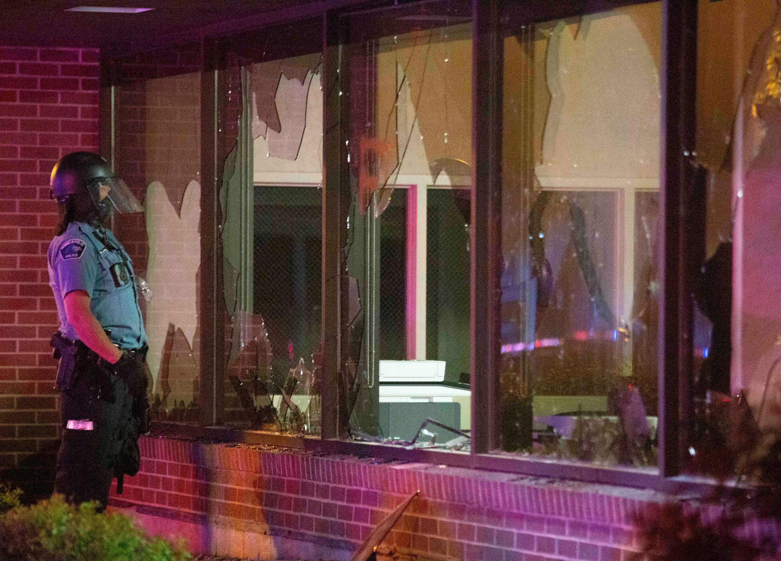  A Minneapolis police officer looks into the window of a US Bank location after looters broke into the bank during a riot over the police killing of George Floyd in Minneapolis, Minnesota on May 28. 