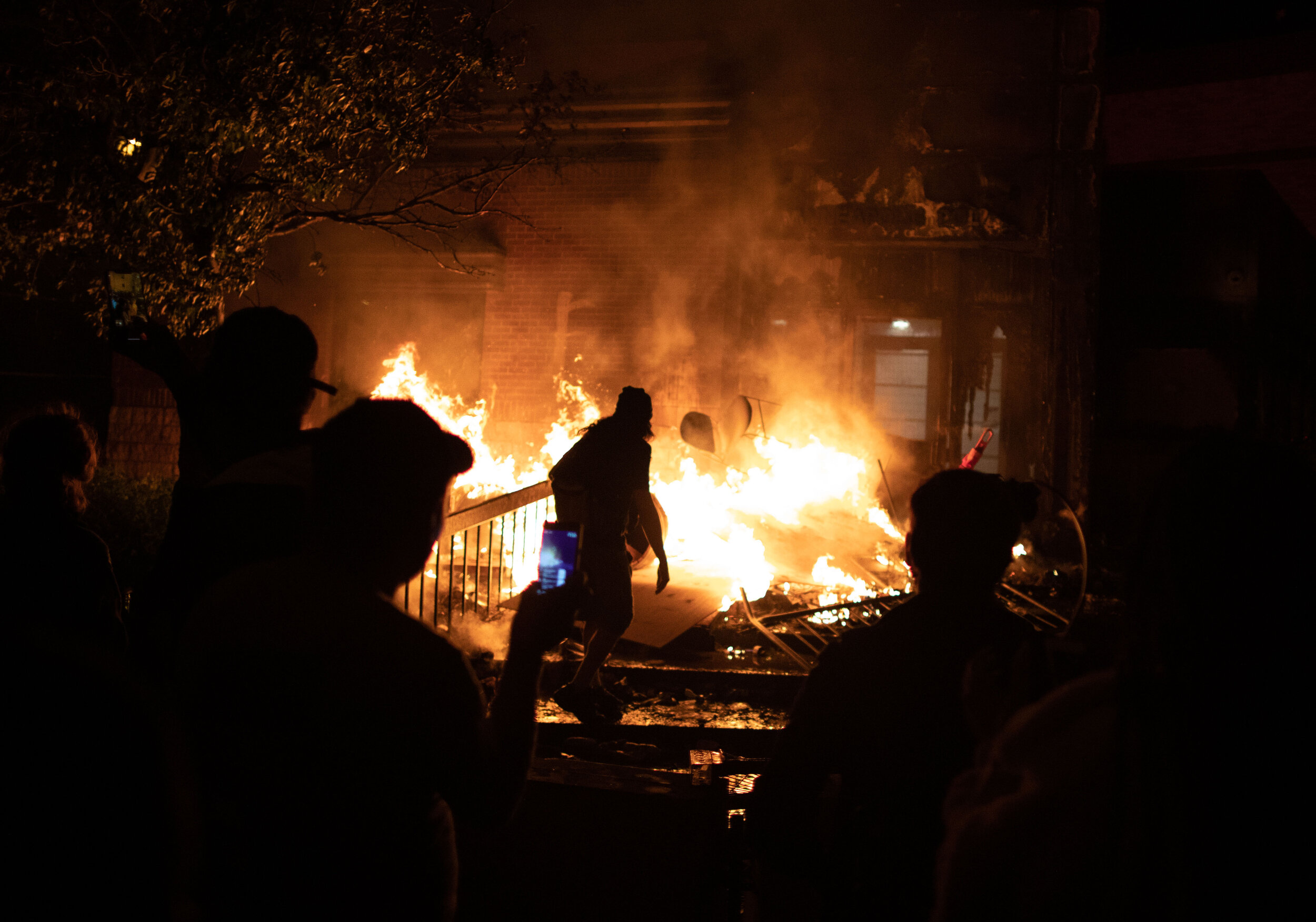  Frozen in mid air, a chair is thrown into a fire by a protester during a riot in Minneapolis at the 3r police precinct over the killing of George Floyd on May 28, 2020. 