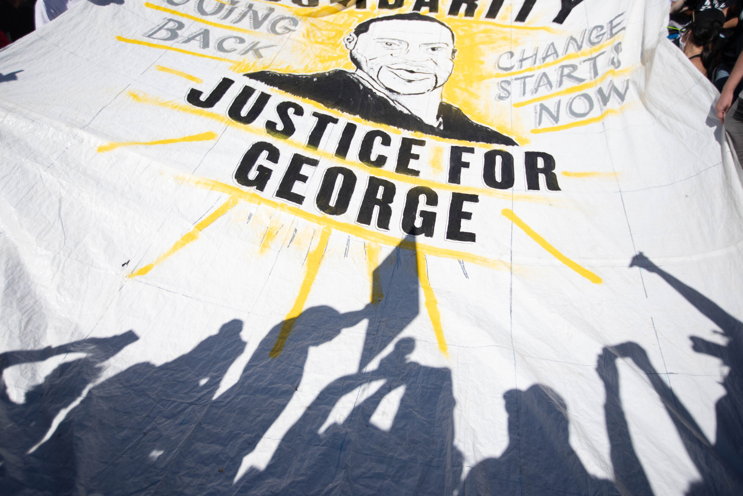  A silhouette of protesters is projected on a banner from the sun during a protest over the police killing of George Floyd in Minneapolis, Minnesota on May 30, 2020. Chris Juhn/Zuma. 
