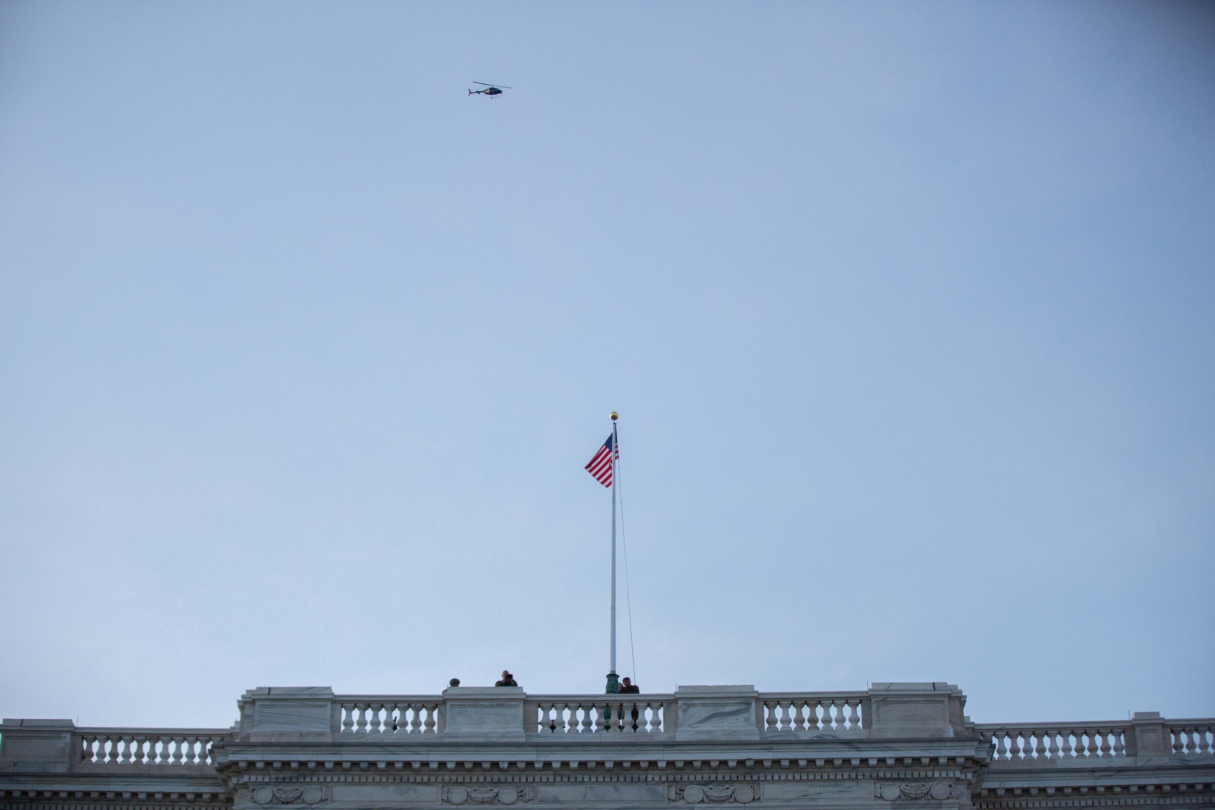  Men with binoculars watch from on top of the Minnesota State Capitol building in Saint Paul, Minnesota as a helicopter flies above them on June 1, 2020. Chris Juhn/Zenger 